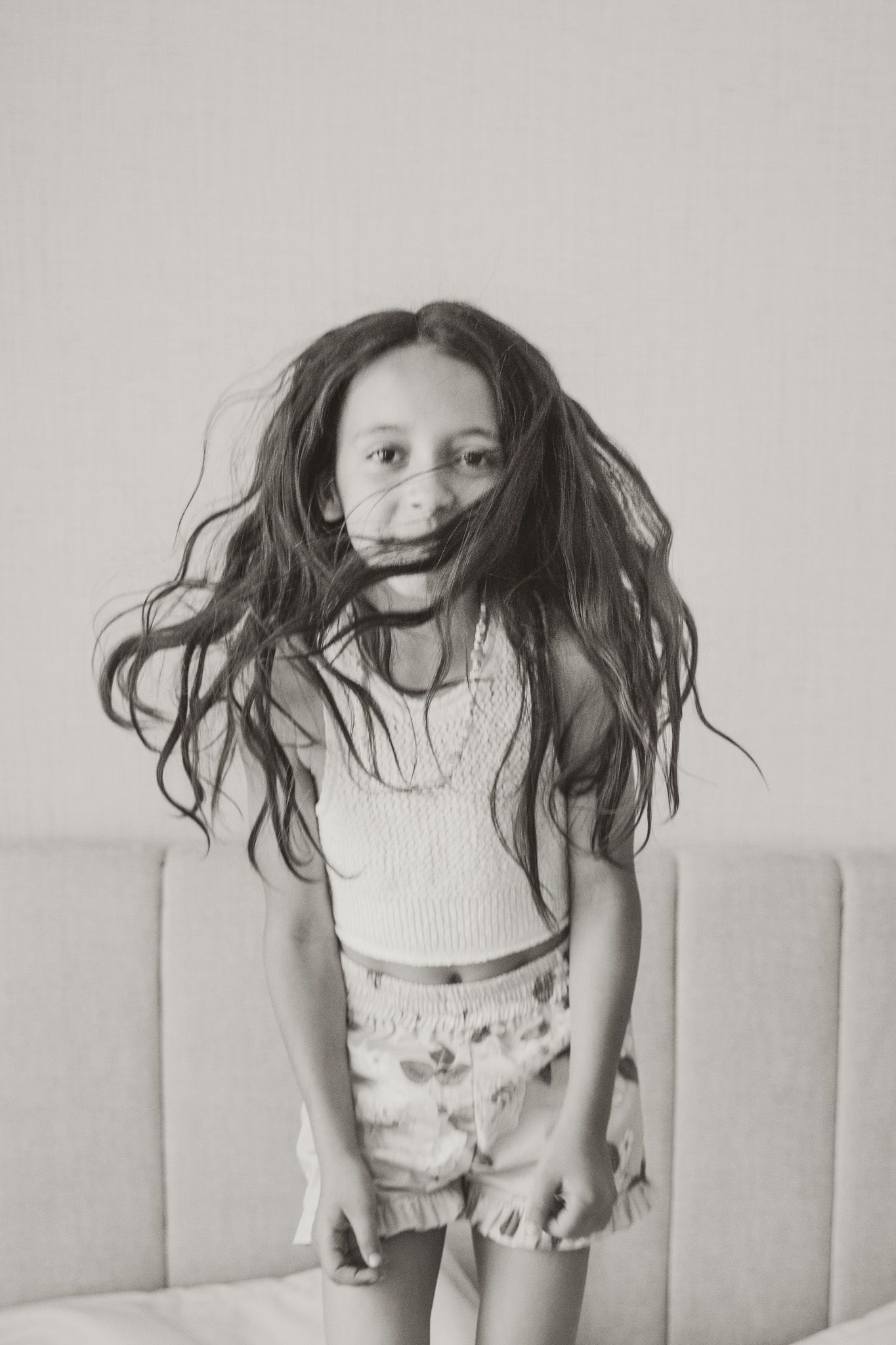 Black and white photos showing playful jumping movements on a couch.