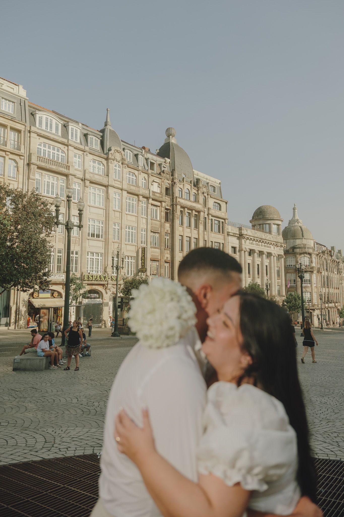 A romantic moment captured in front of historic European architecture with cobblestone streets.