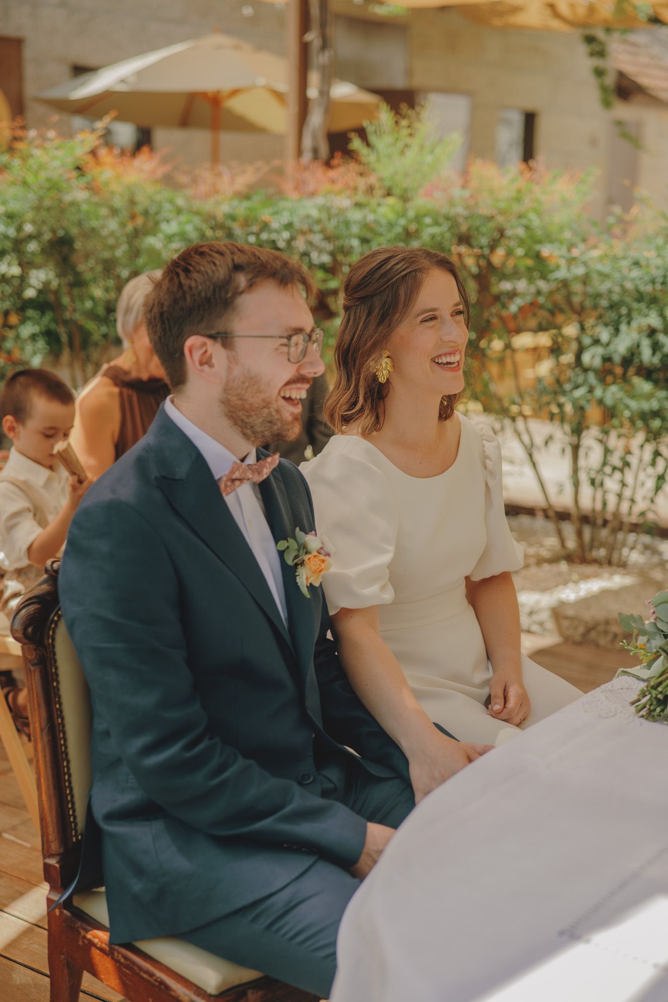 A joyful moment shared between guests at an outdoor wedding reception under a canopy.