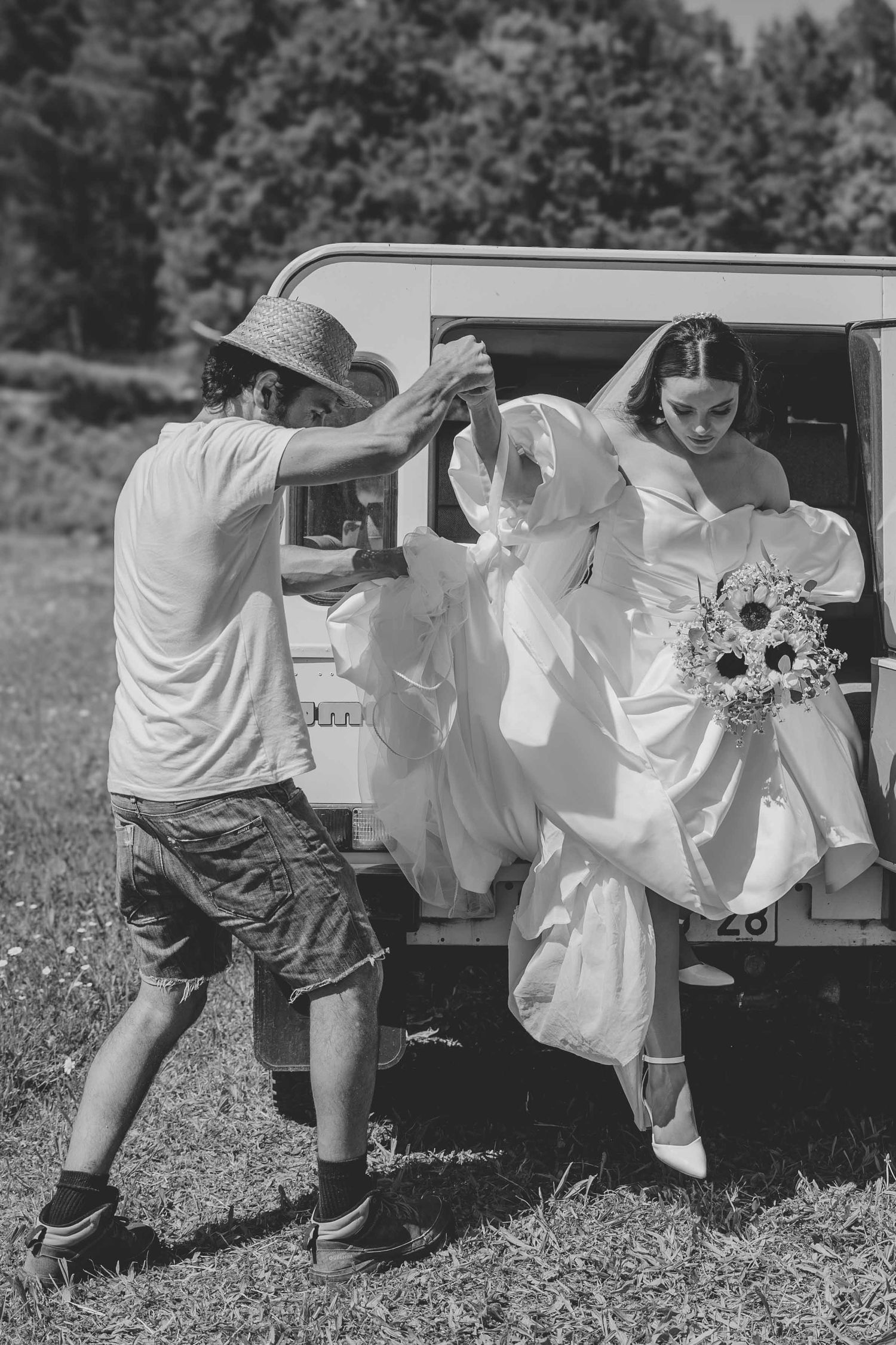 Black and white photo series showing a couple playfully posing by a vintage truck in a wildflower field.