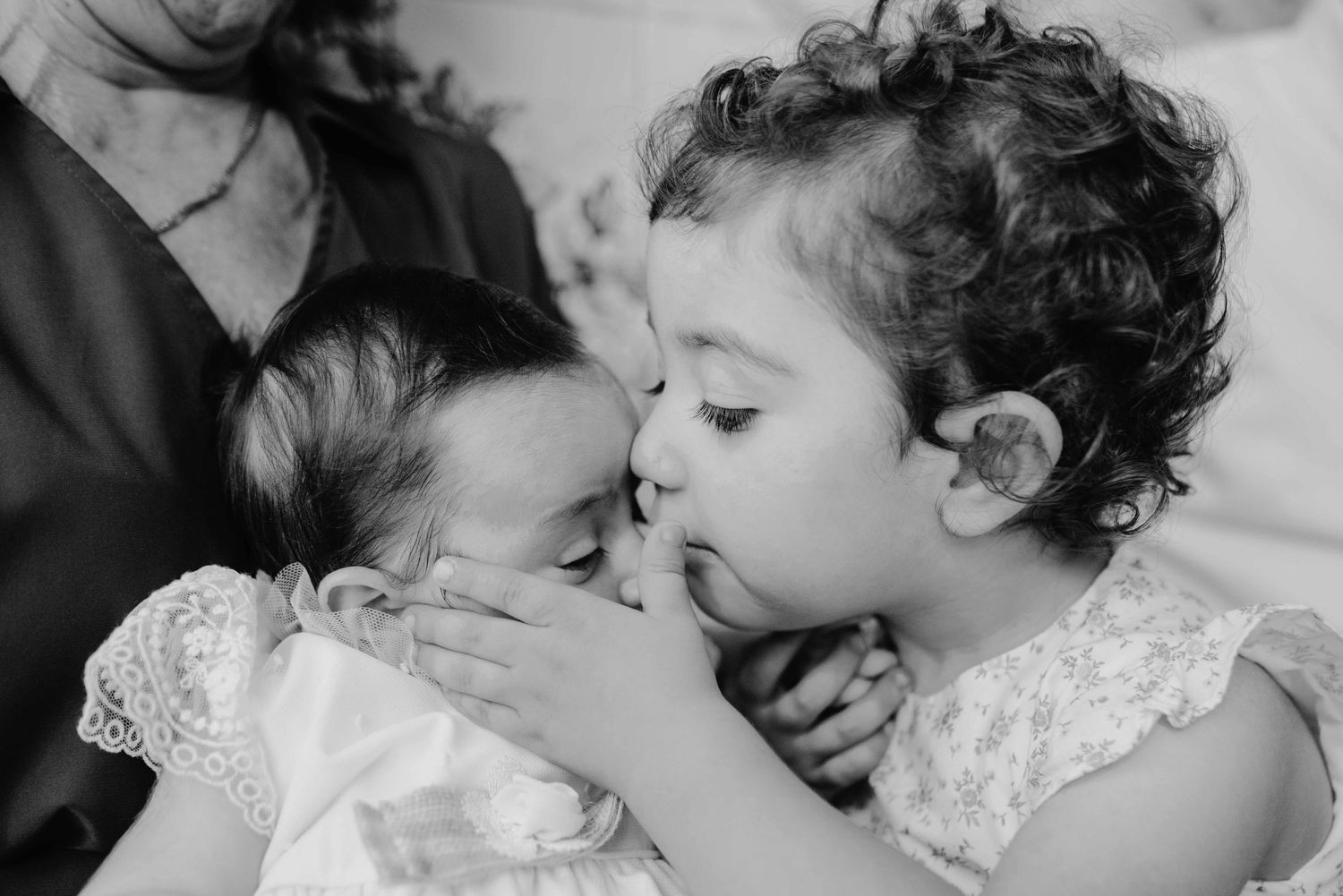 A series of seven black and white photos showing tender moments between a parent and child.