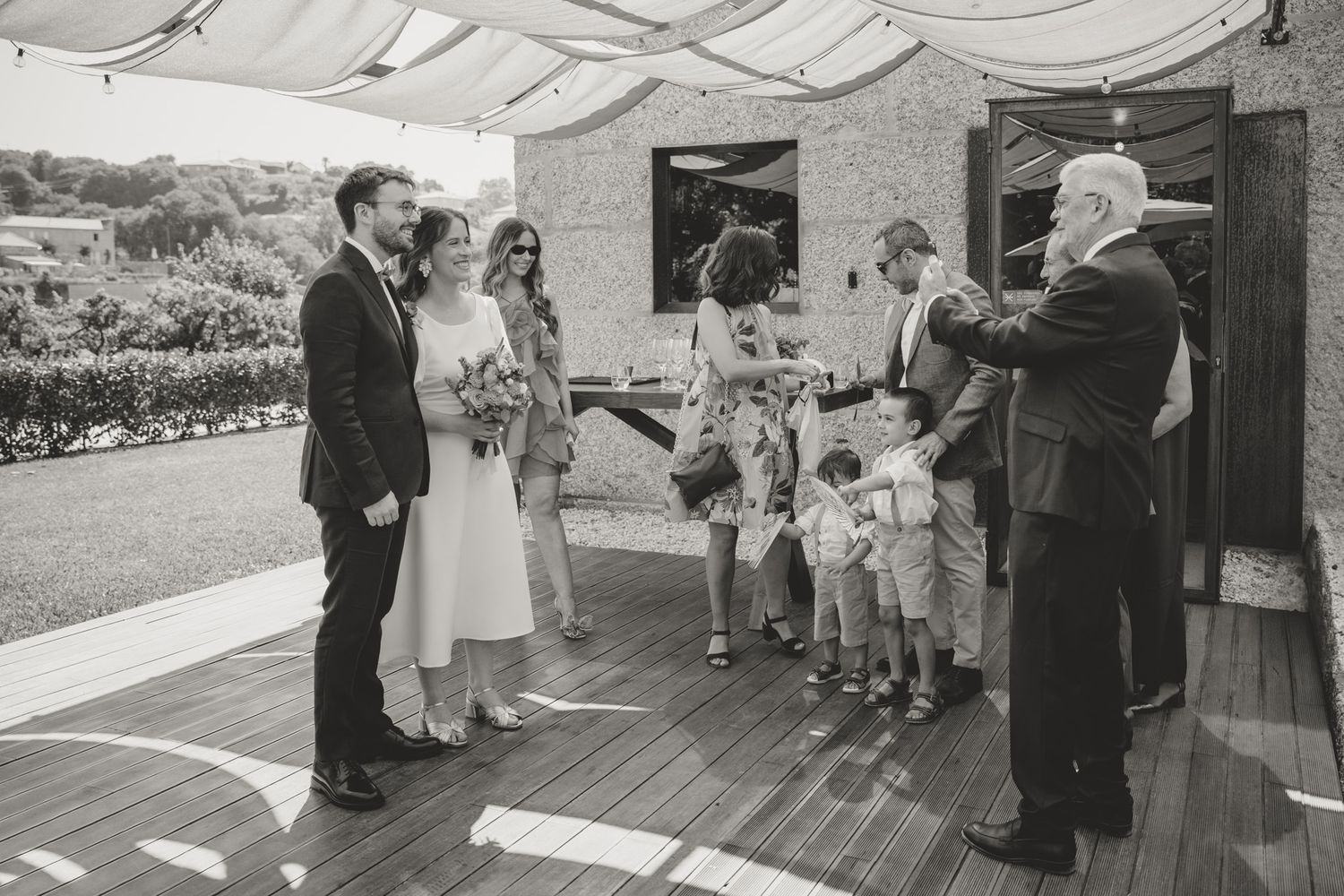 Wedding guests gathered on a covered outdoor deck for a celebration.