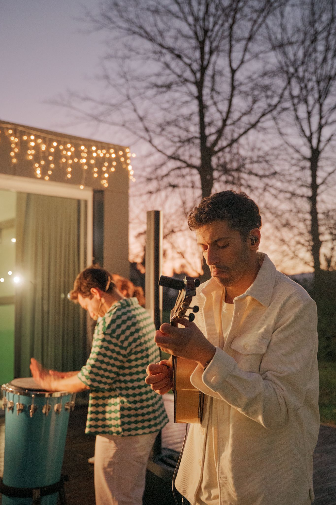 People dancing and celebrating at an outdoor evening wedding reception with string lights.