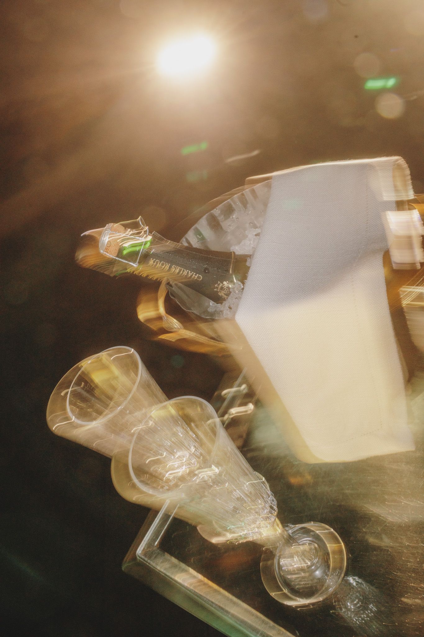 Motion blur sequence of champagne glasses with golden lighting effects.