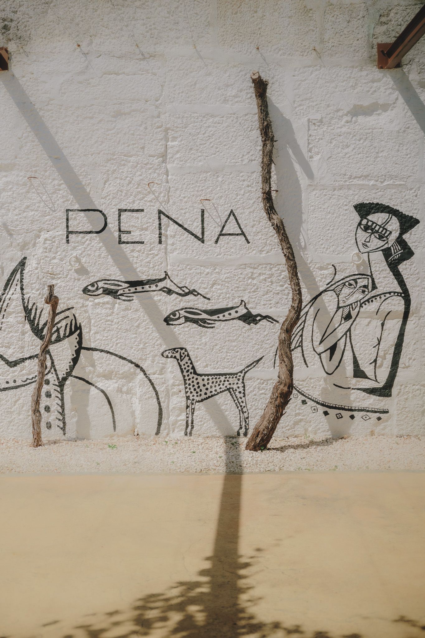 Line art drawings on a white wall with sketched figures and designs.