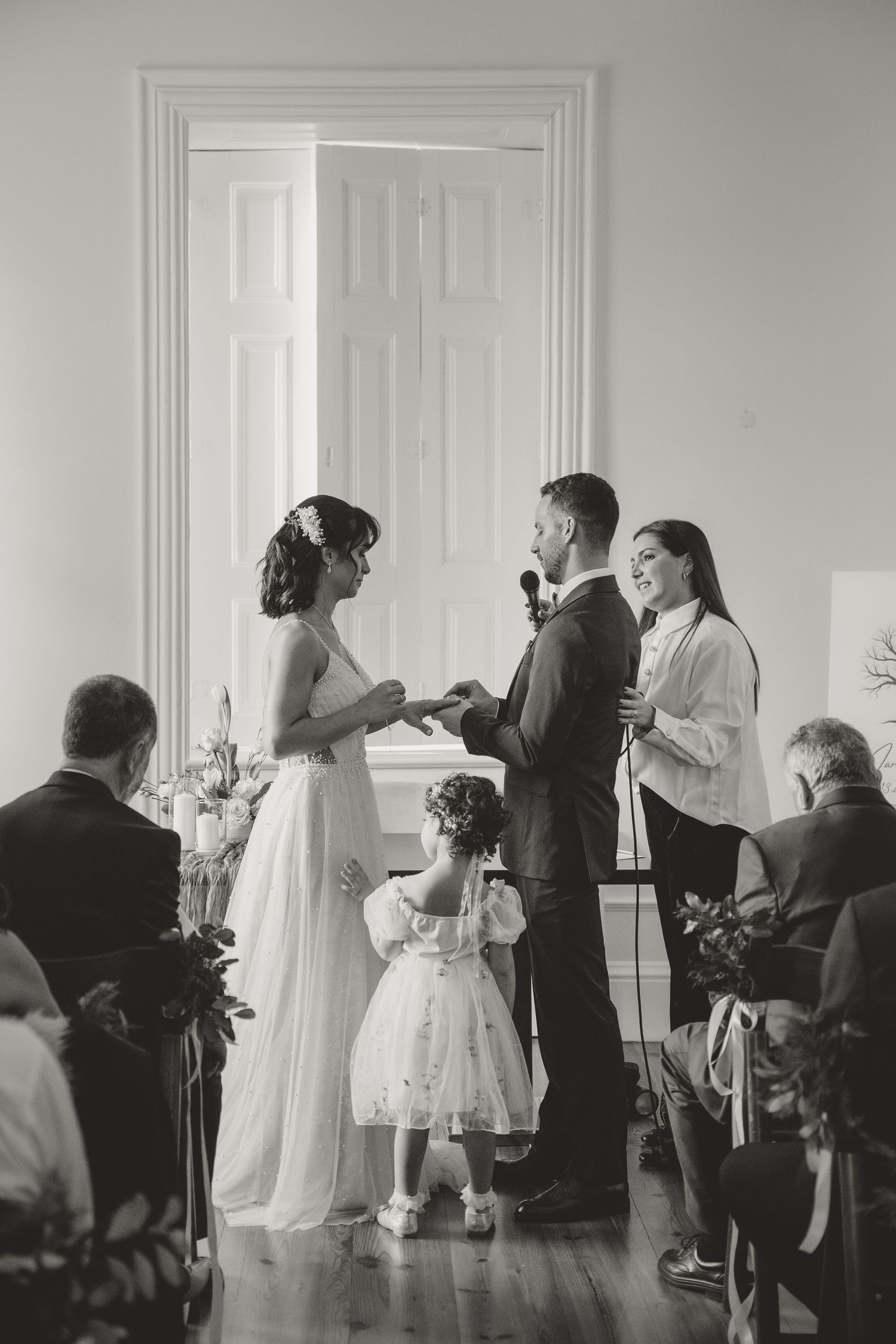 Wedding guests dance and celebrate in an elegant white room with classic decor.