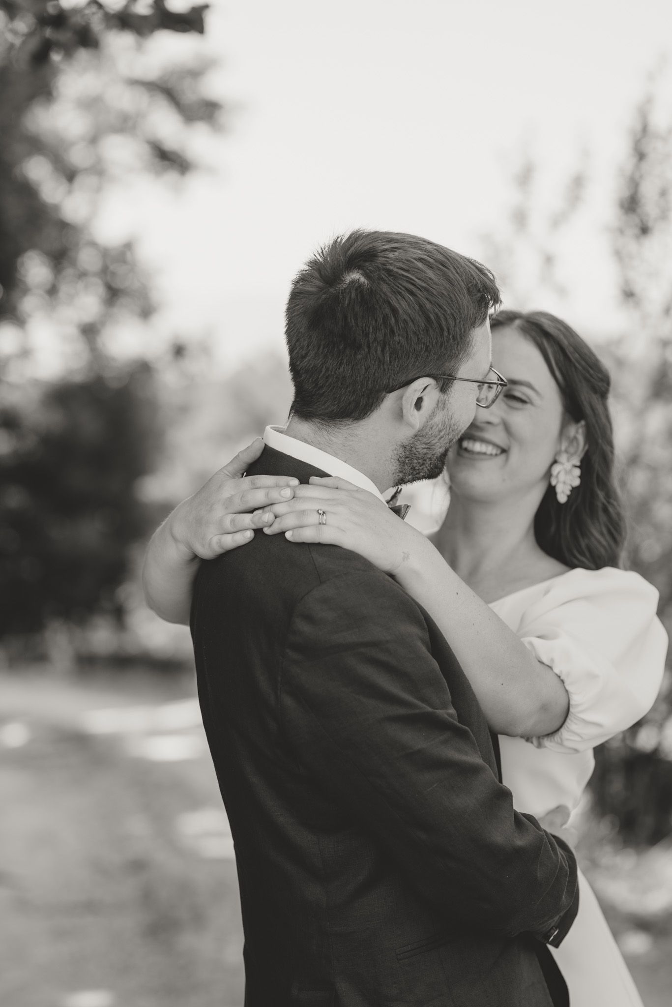 Intimate wedding couple embrace in romantic outdoor setting.