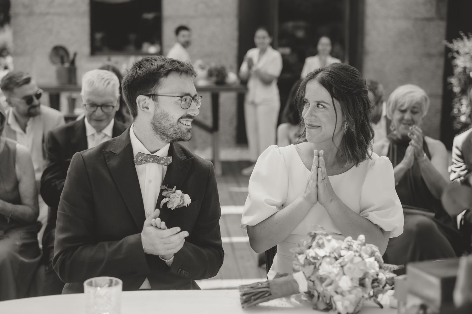 Wedding guests share emotional reactions during a special moment at the reception.