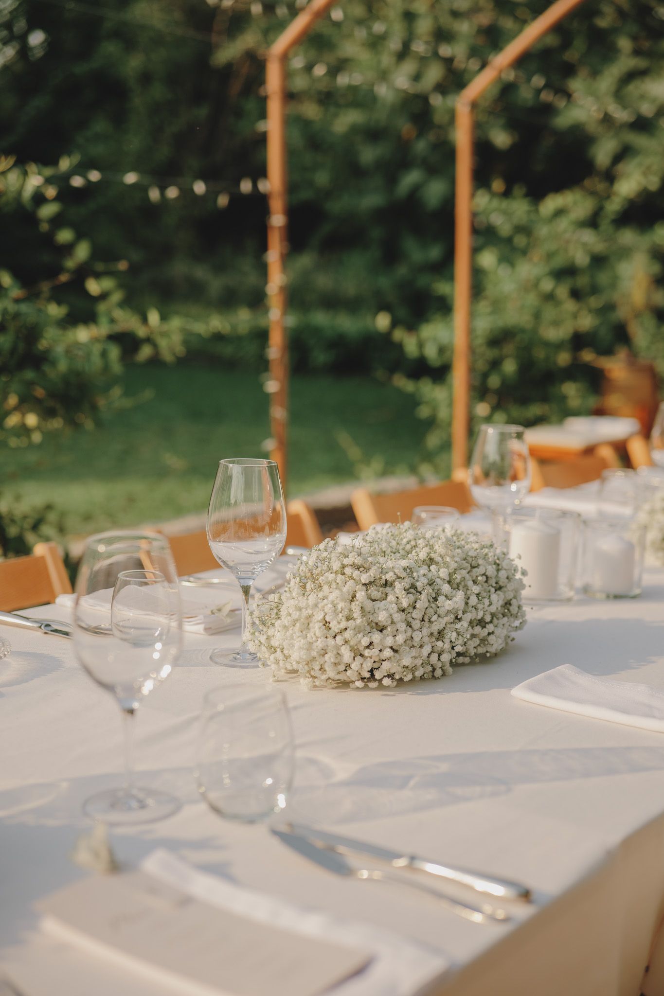 Elegant table setting with baby's breath centerpiece and wine glasses.