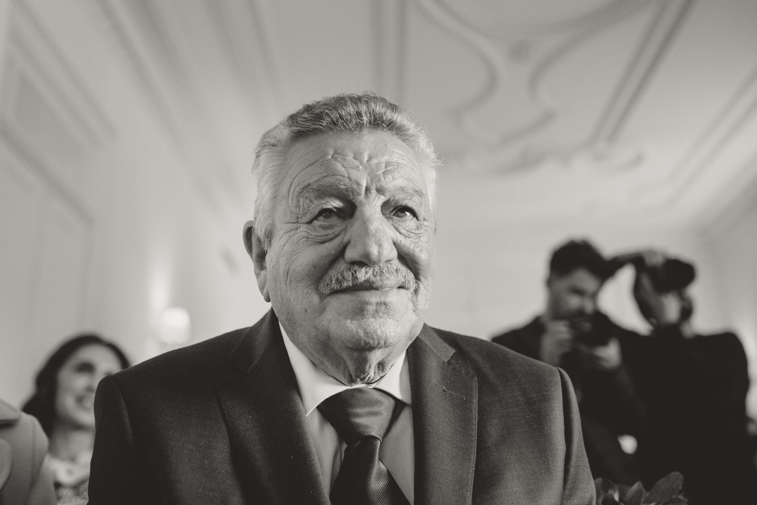 Black and white candid shot of wedding guests enjoying emotional moments at reception.