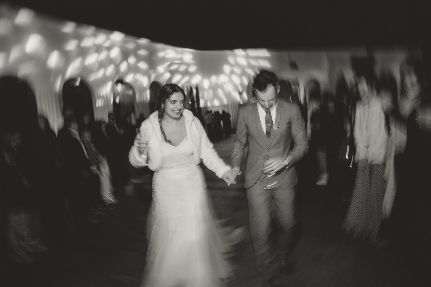 Wedding reception dance floor with guests celebrating and dancing in black and white.