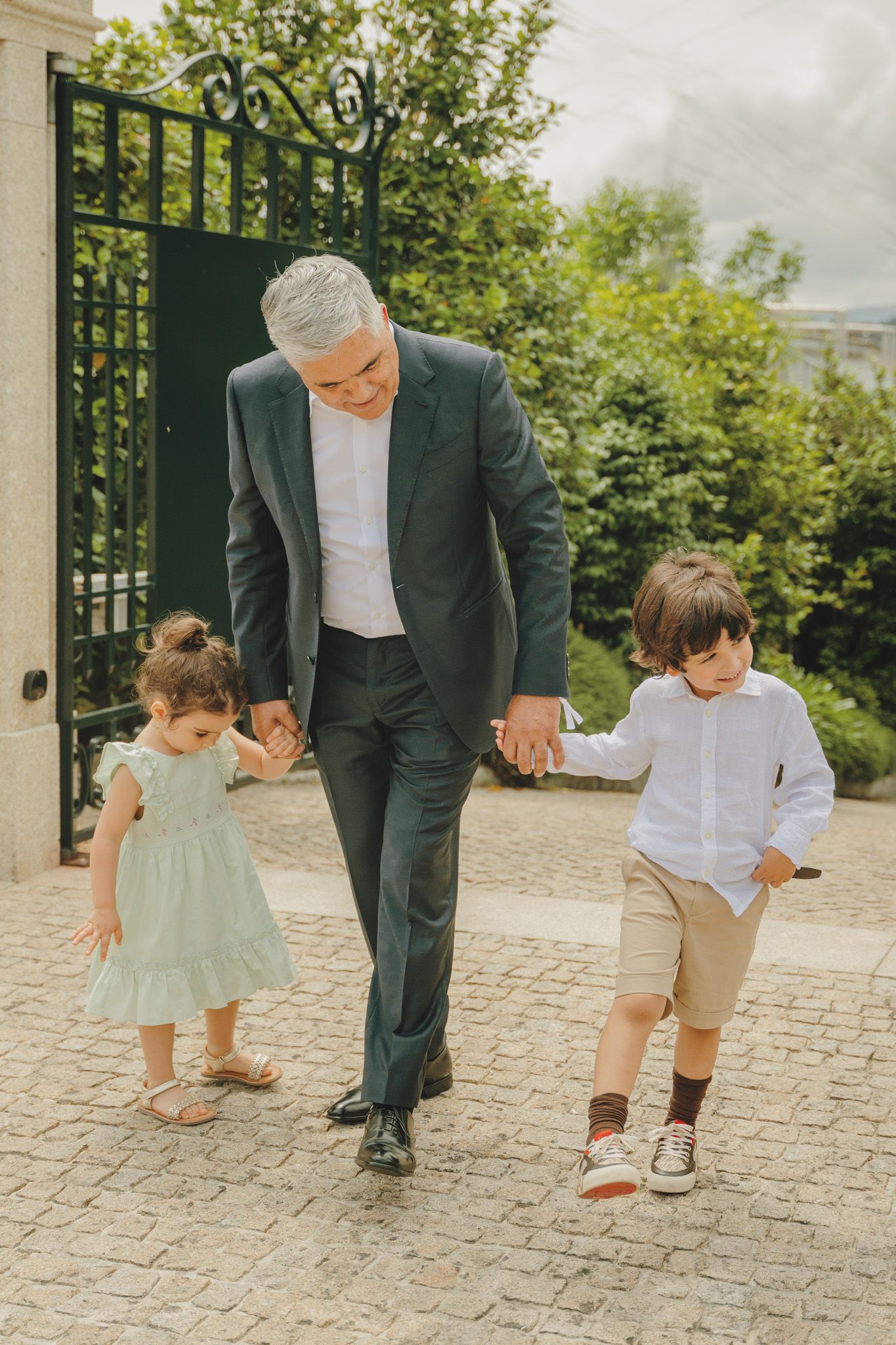 Candid moments of play and movement captured on a stone walkway surrounded by greenery.