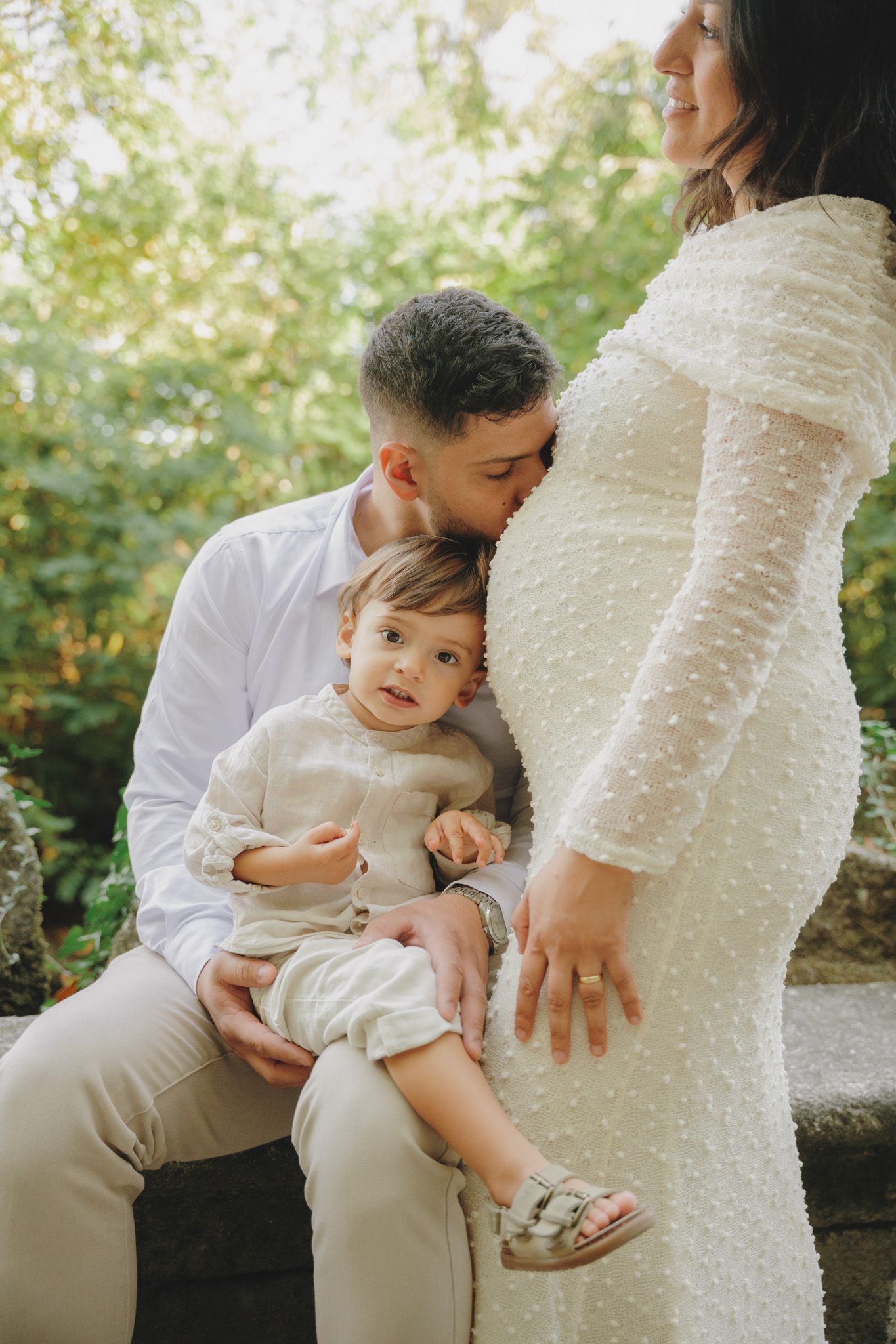 An intimate family moment captured during a maternity photoshoot in nature.