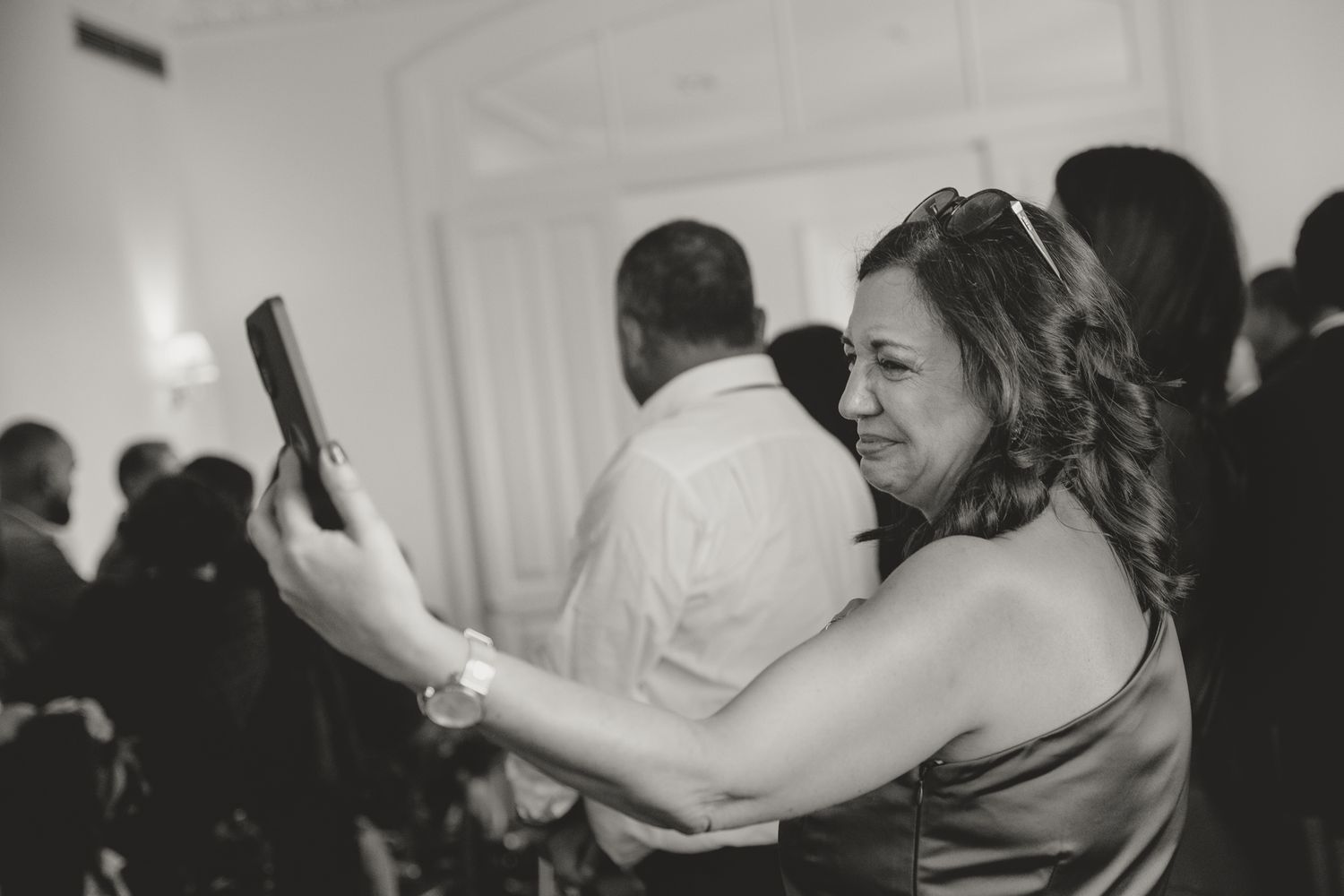 Candid moments of celebration captured in black and white at an indoor venue.