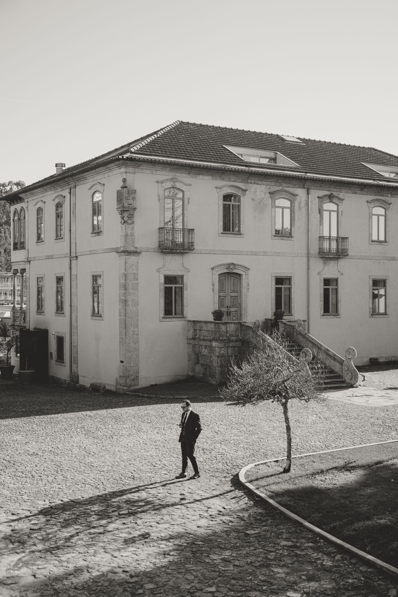 Black and white view of a historic building exterior with cobblestone courtyard.
