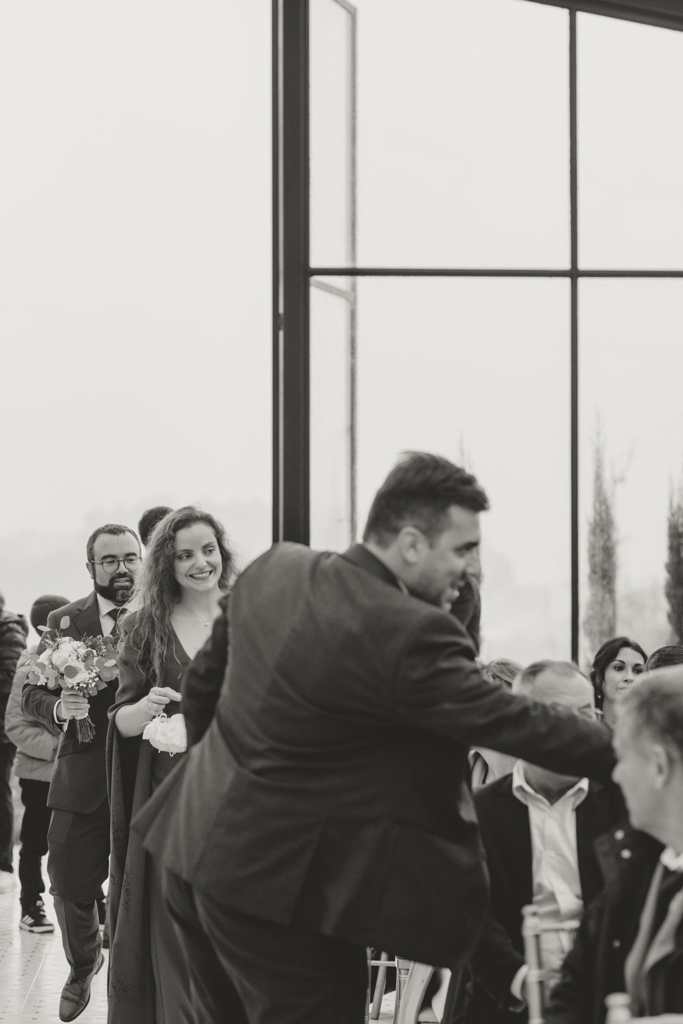 Wedding guests dance and celebrate together in a bright indoor venue.