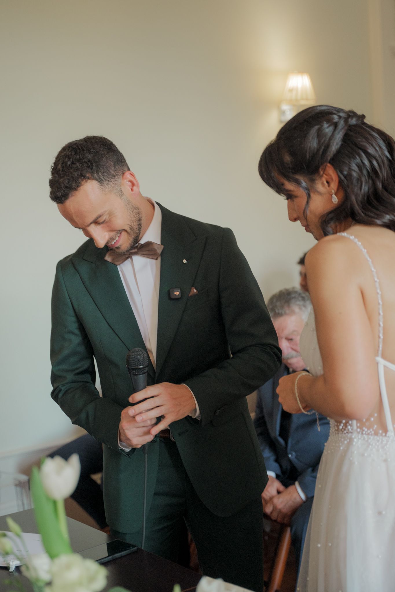 Candid wedding moment showing couple's emotional first look in a bright indoor setting.