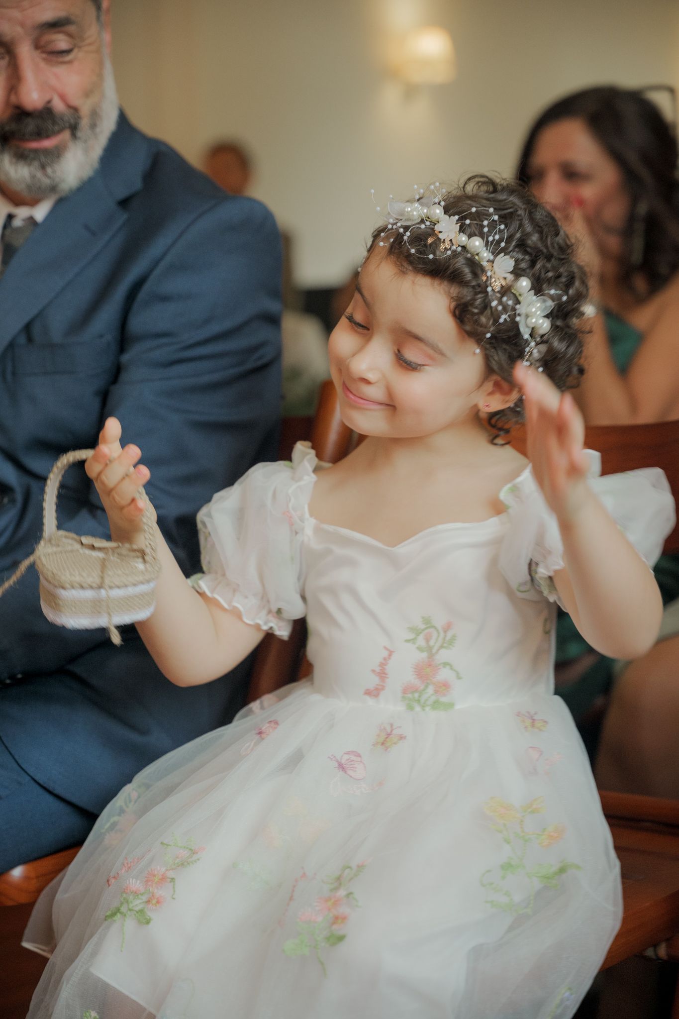 Young attendee in a white floral dress with delicate embellishments enjoying the wedding celebration.
