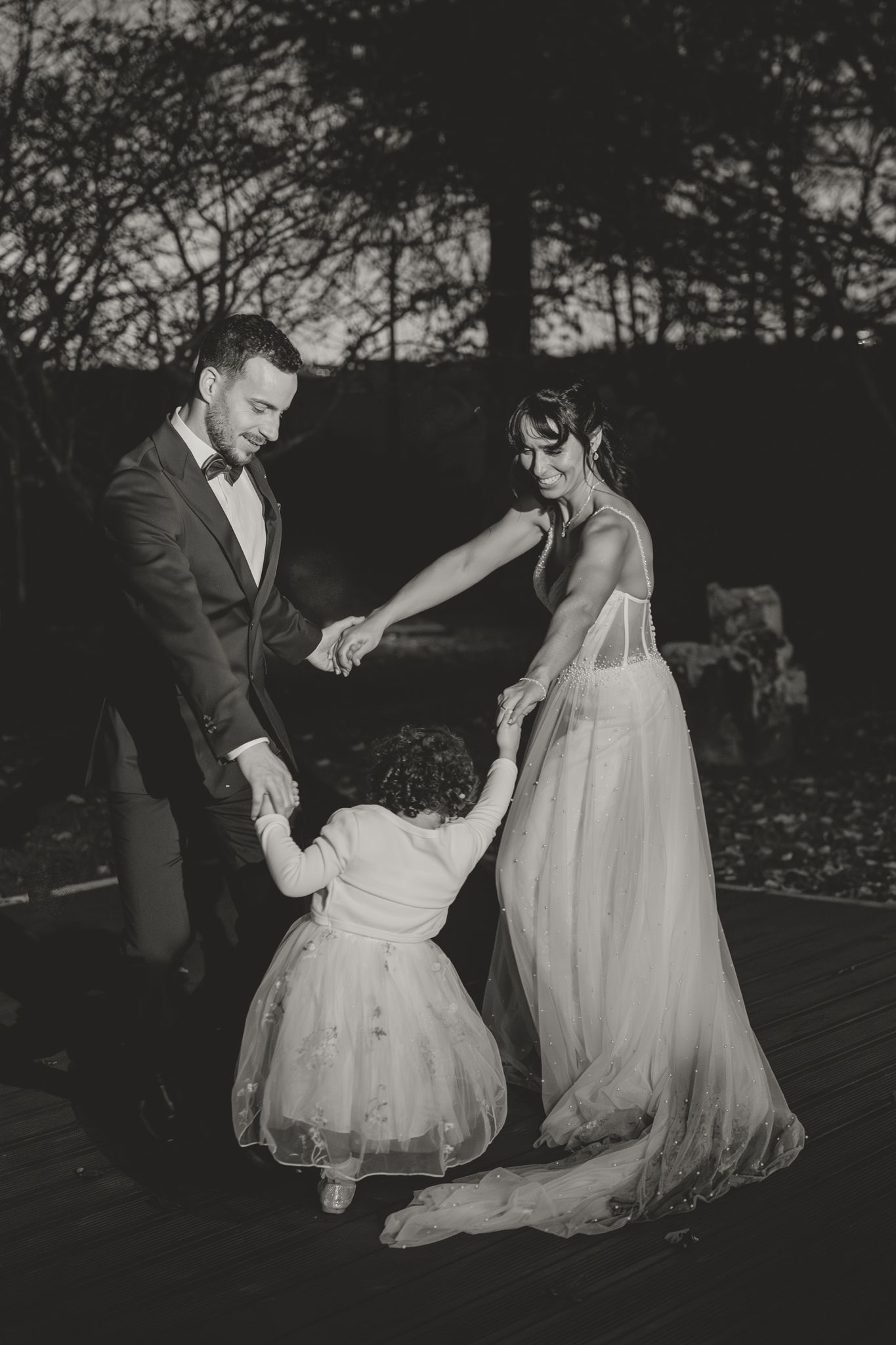 A couple shares a tender moment during their wedding reception at dusk.