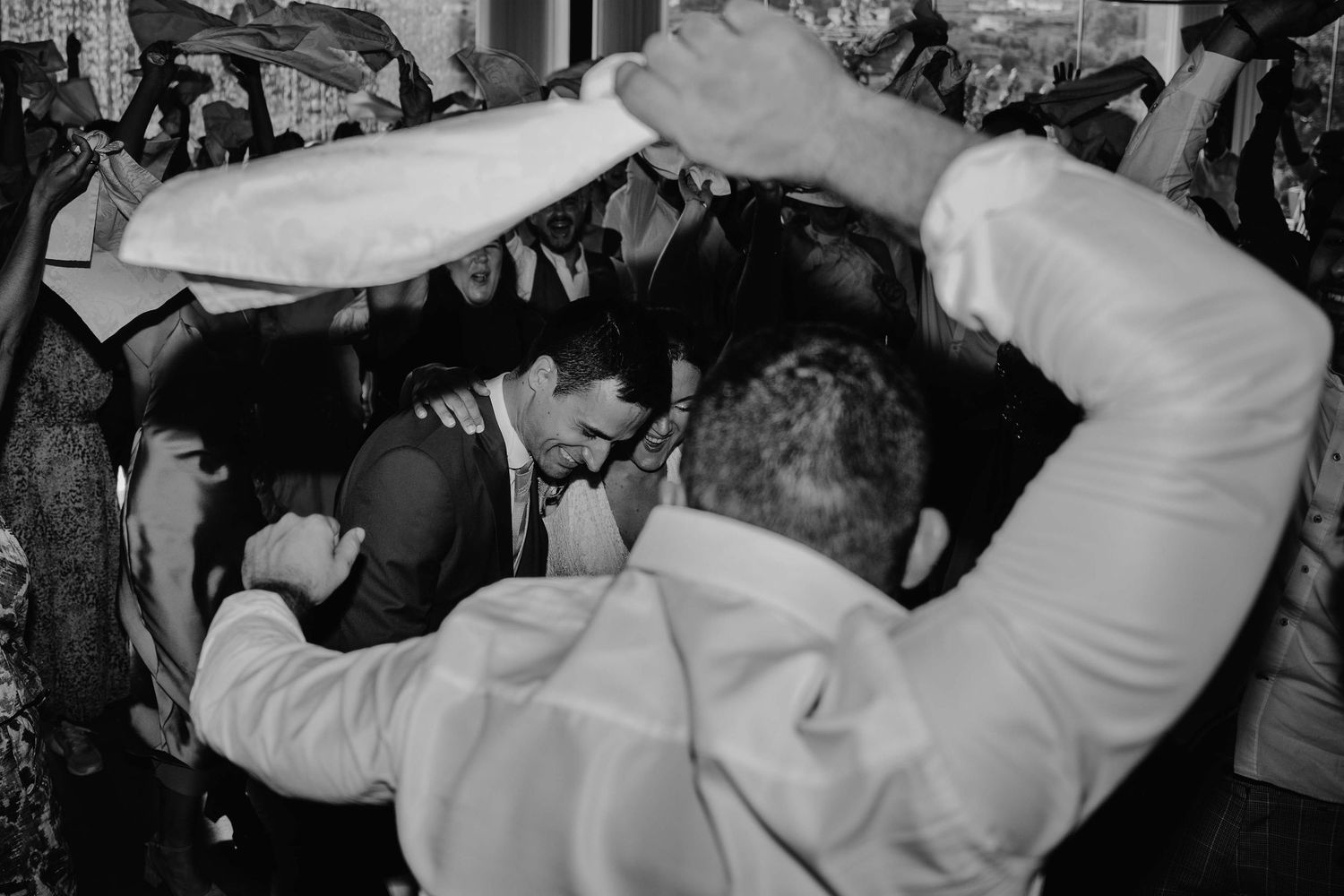 Black and white photo series showing people dancing and moving energetically at what appears to be a party or celebration.