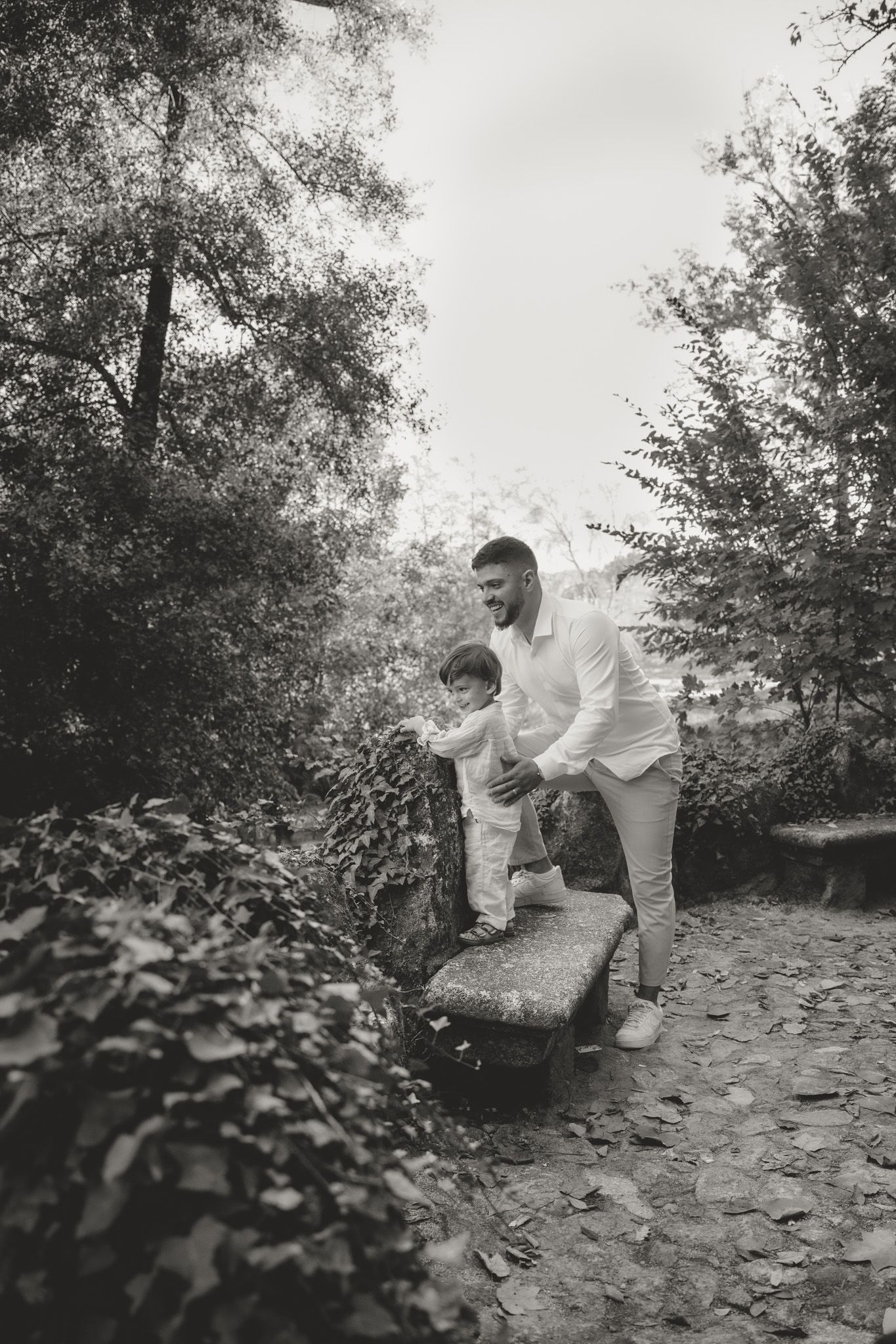 Black and white photo of family playing together on stone path.