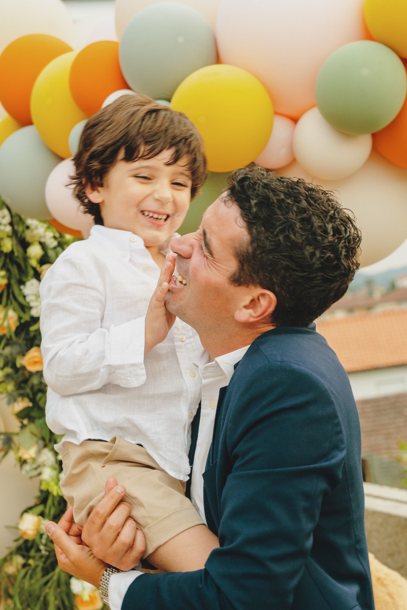 A joyful celebration moment against a backdrop of colorful pastel balloons.