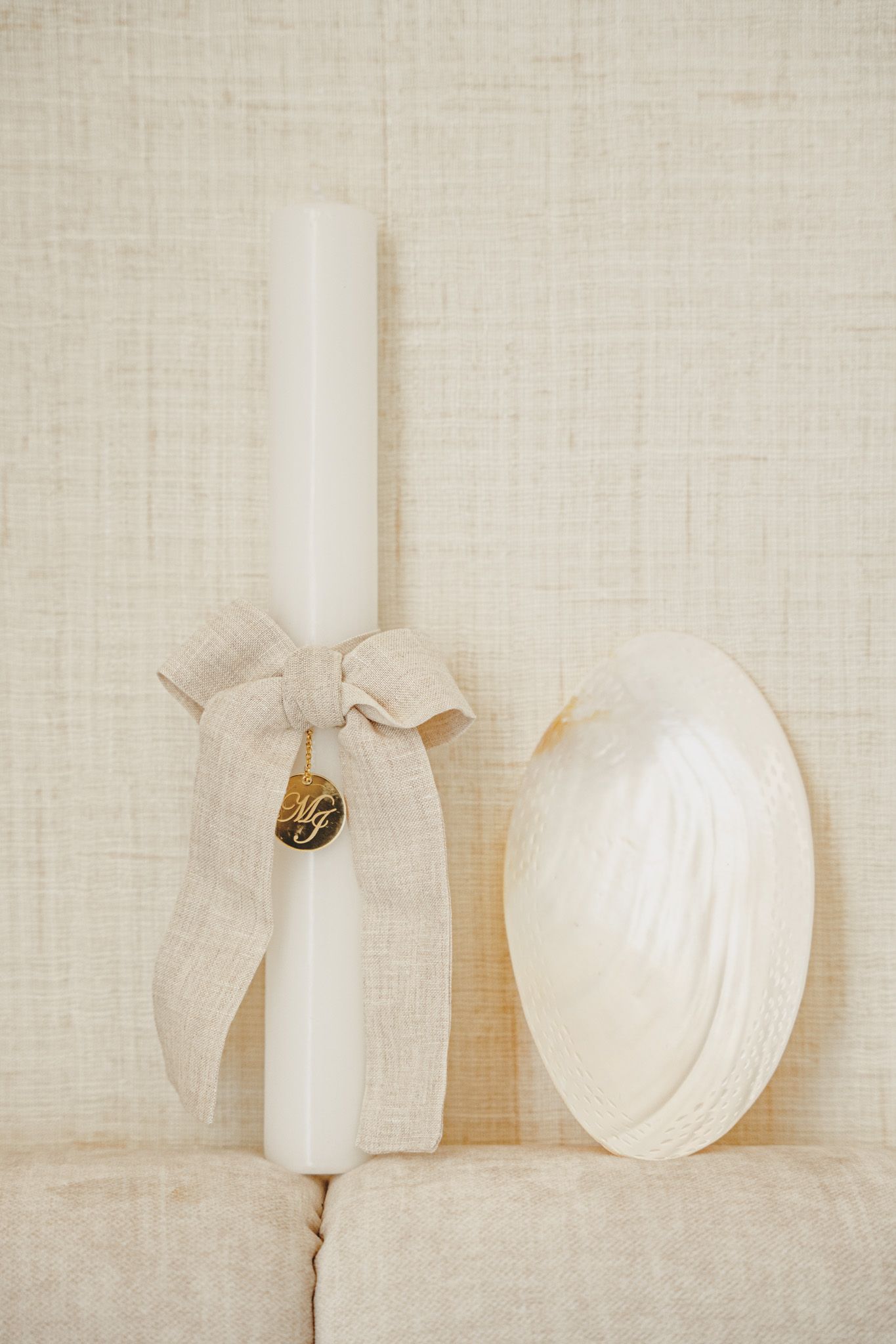 Minimalist still life of white fabric bows and decorative elements against light background.