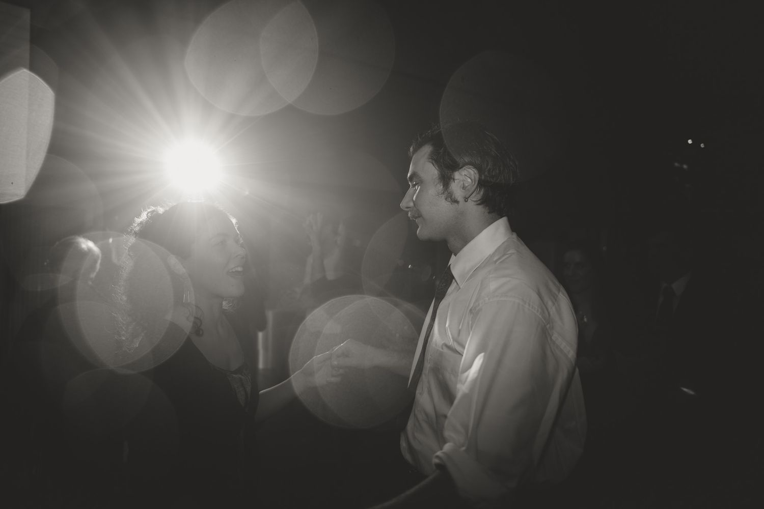 Dramatic black and white wedding dance photos with lens flares and artistic lighting effects.