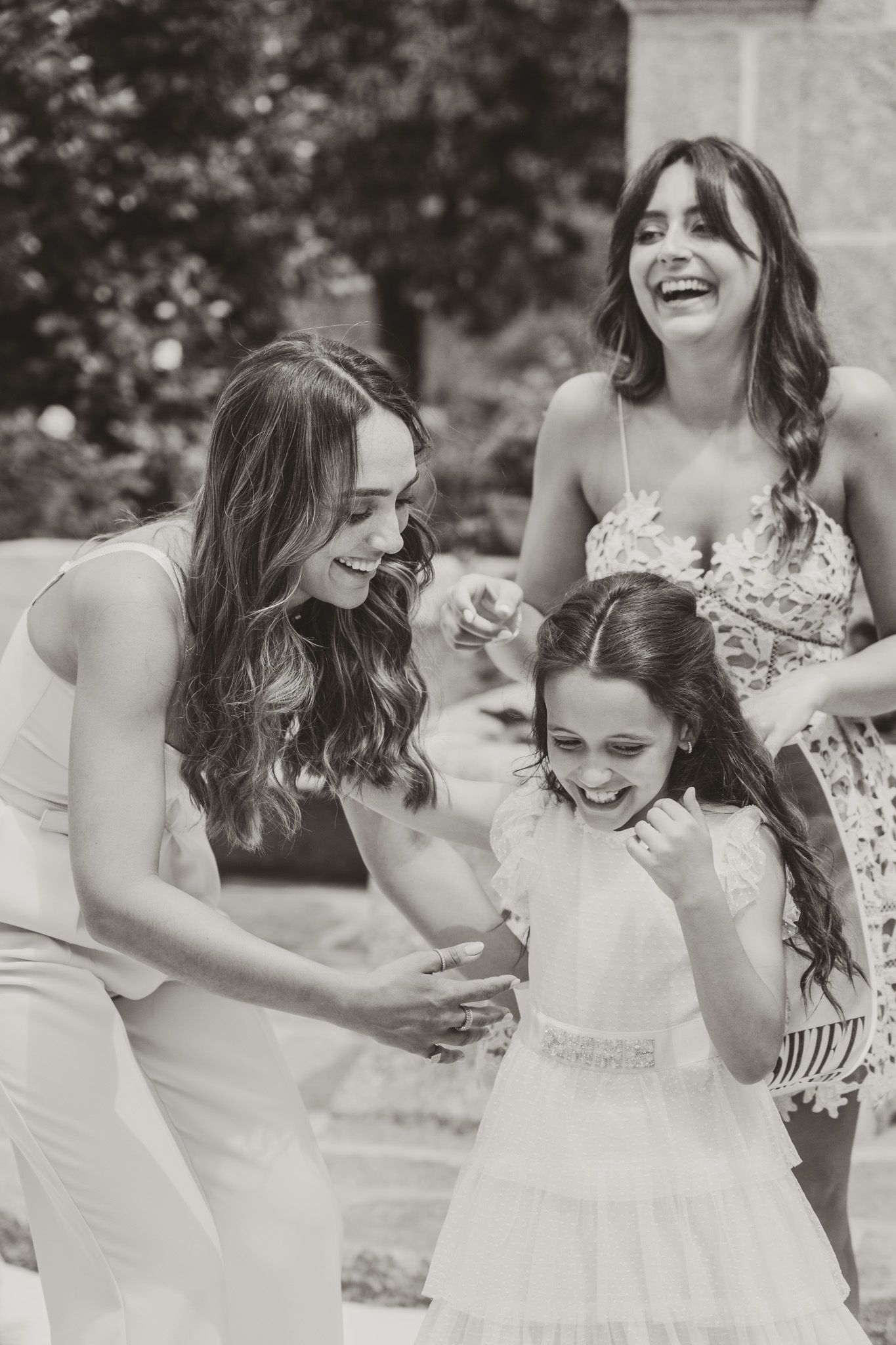 Joyful moment captured in black and white showing people in formal white attire.