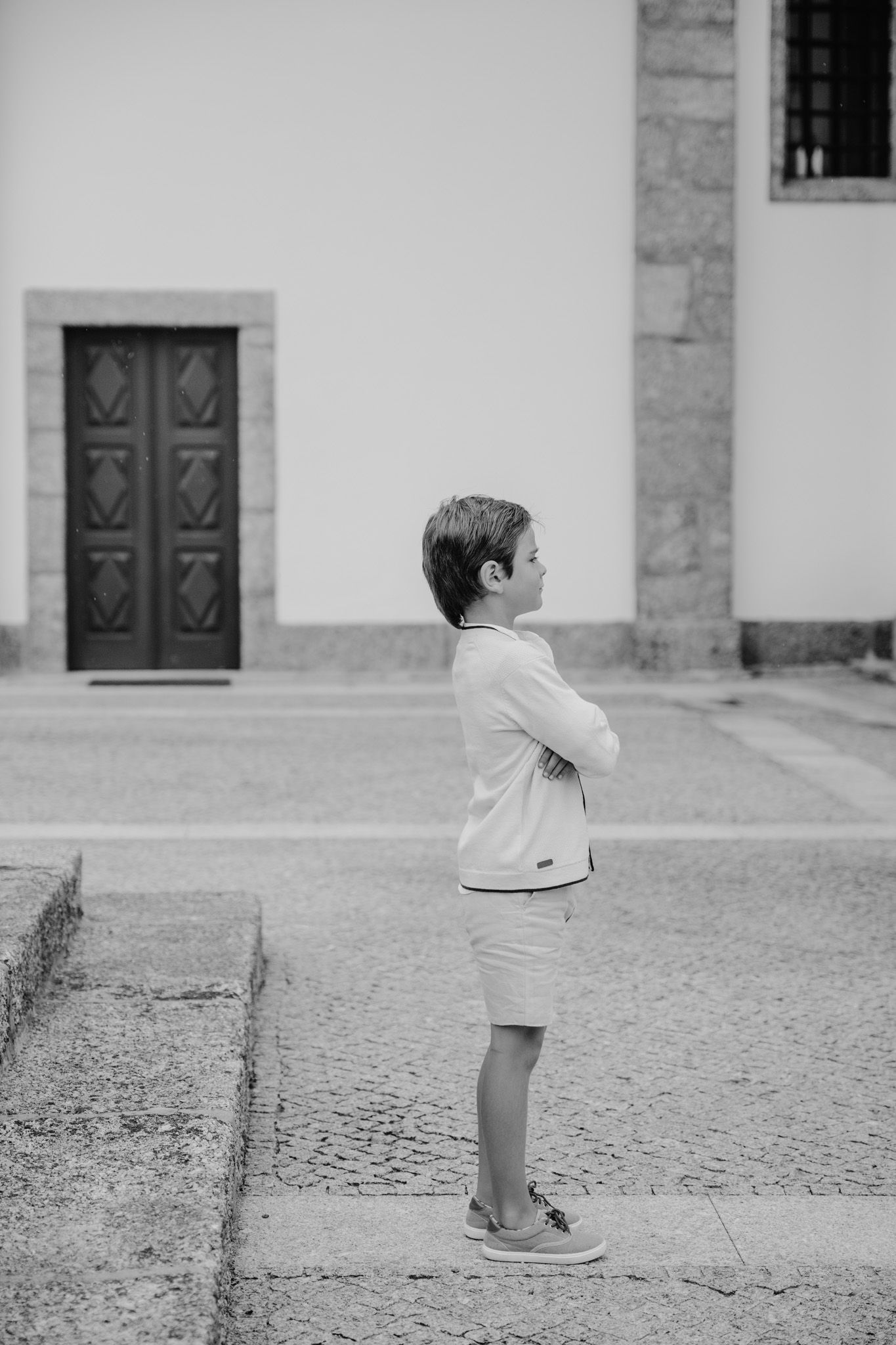 Black and white sequence of a child walking along a stone courtyard.