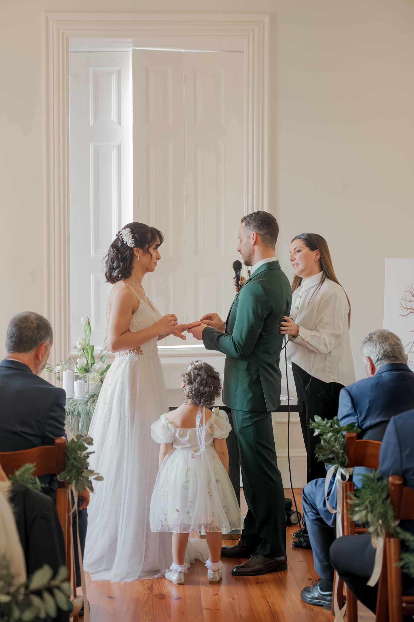 Wedding ceremony sequence showing interactions between couple and flower girl in white dress.