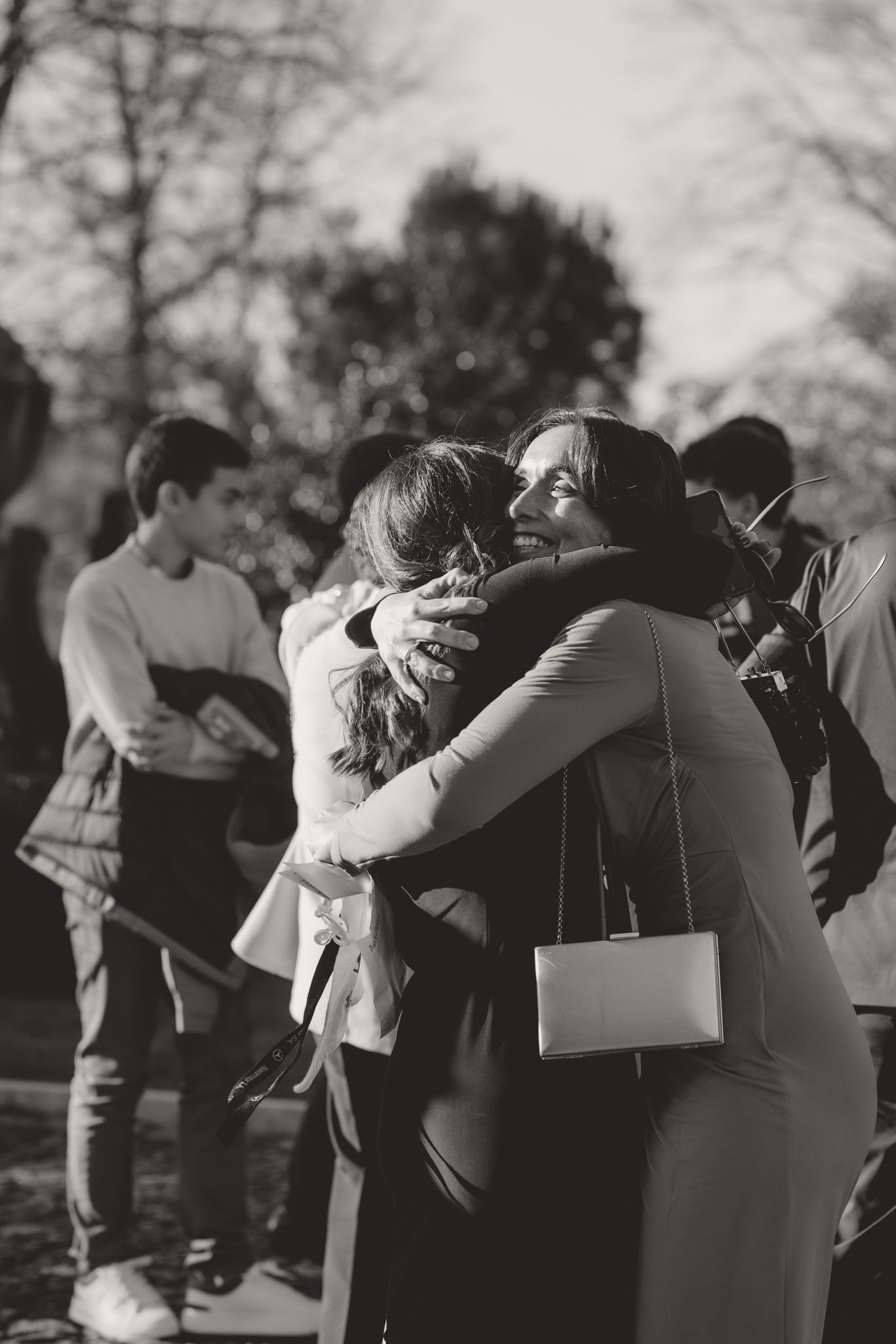 Emotional group hugs and embraces captured in black and white at an outdoor gathering.