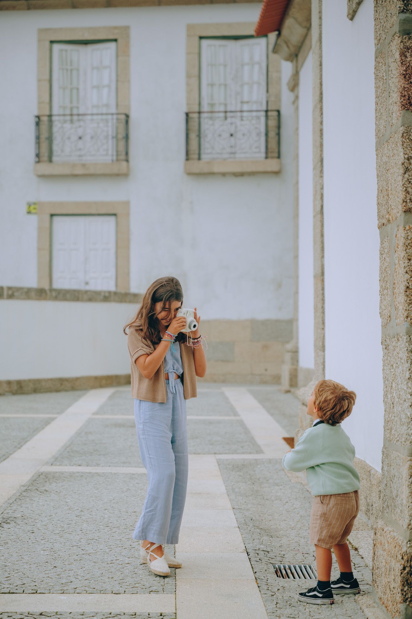Sequence showing playful interactions in front of a white building facade.