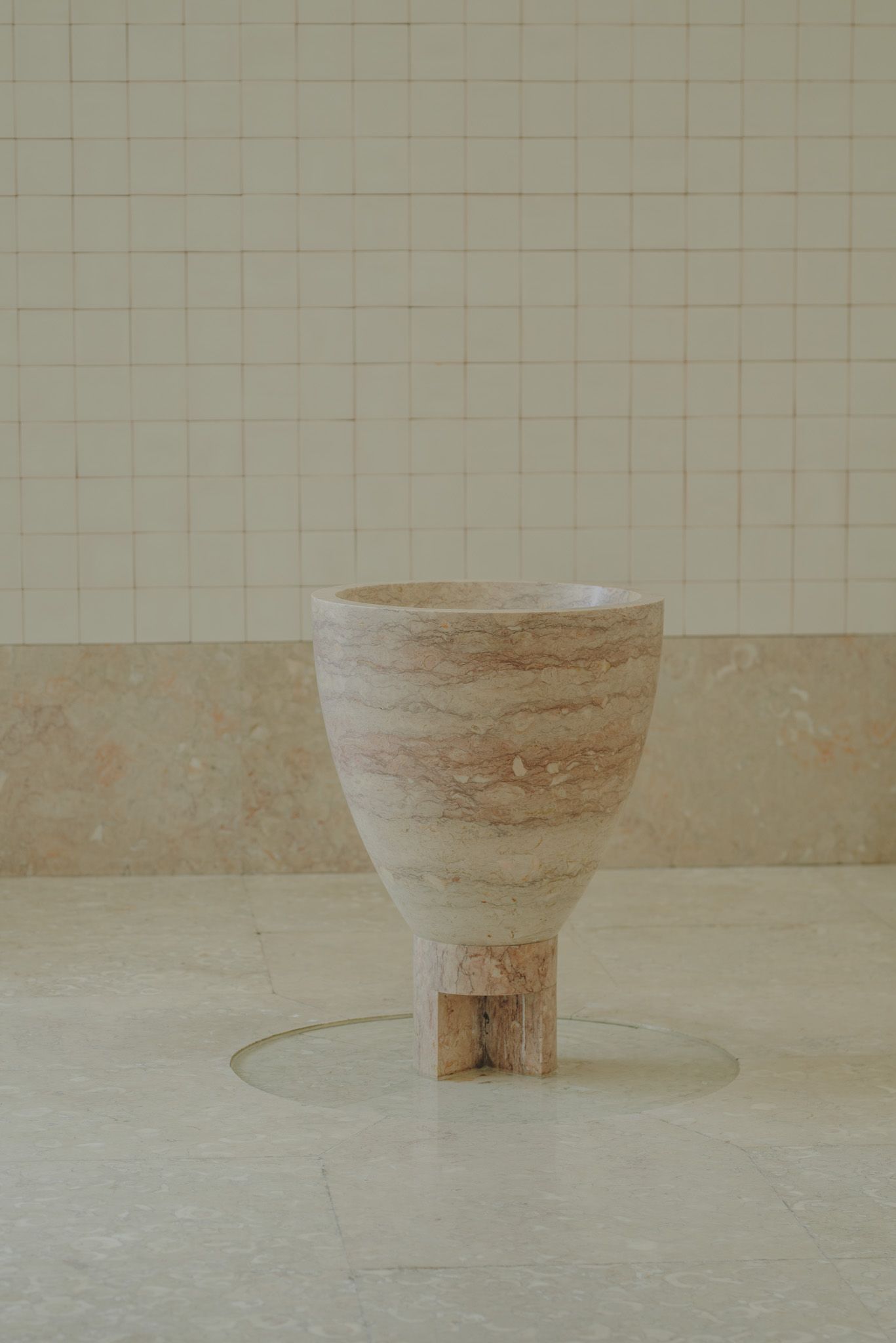 A series of minimal images showing a textured ceramic vessel on a tiled floor.