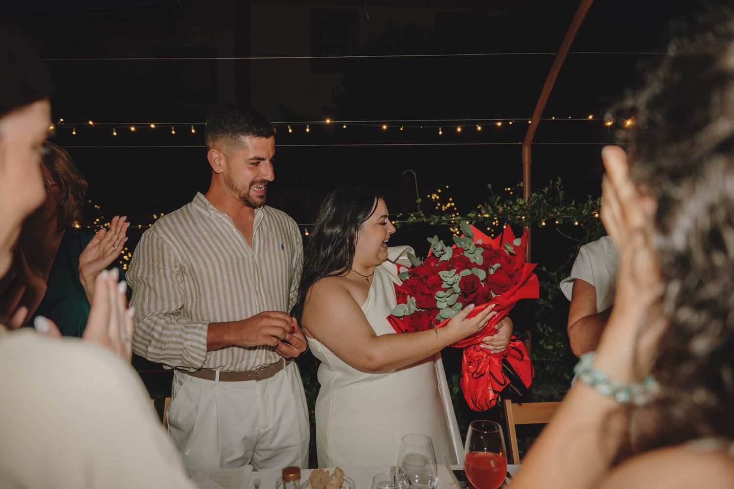 Guests at an outdoor wedding reception sharing emotional moments together.