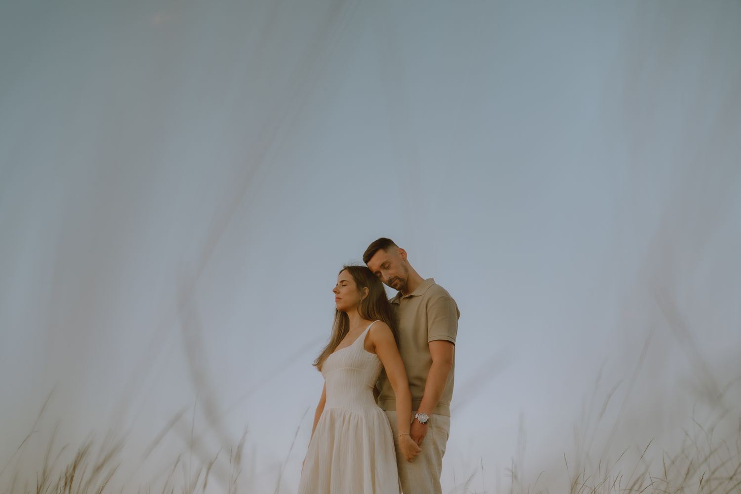 Couple sharing tender moments in a minimalist setting with soft lighting.