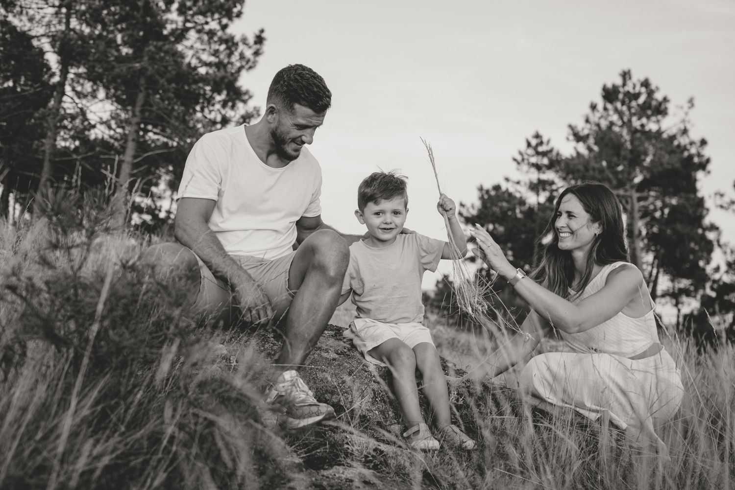 Black and white series of family enjoying time together on natural outdoor terrain.