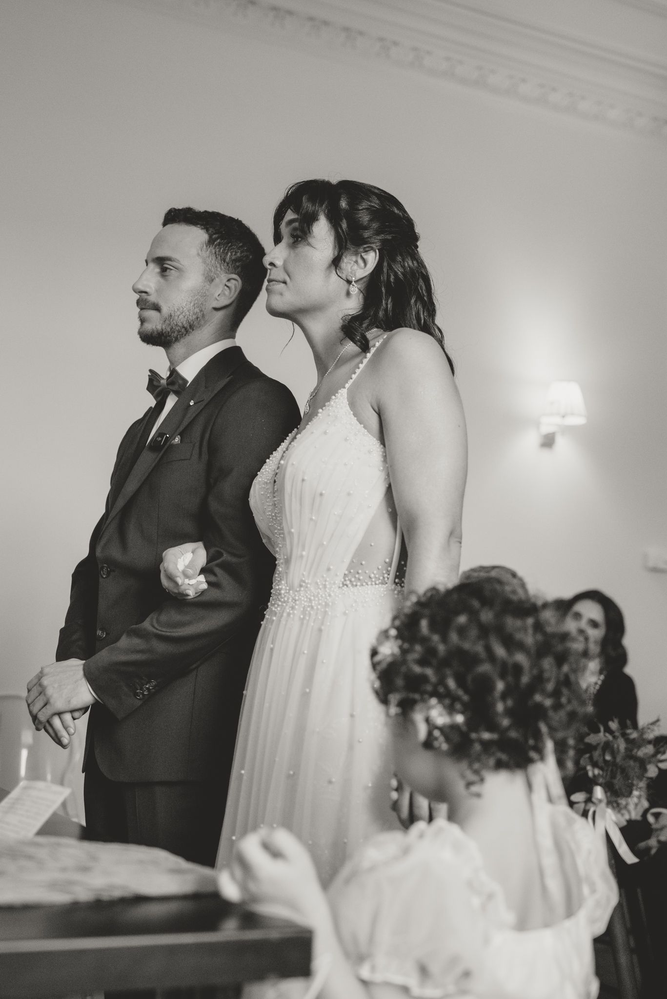 Black and white wedding ceremony photos showing couple standing together at the altar.
