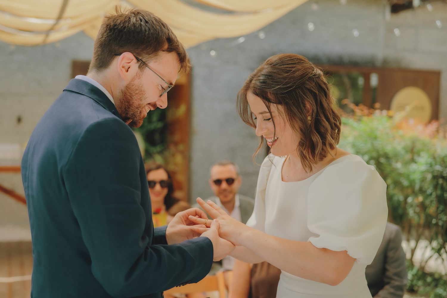 A candid celebration moment captured under an outdoor canopy with natural lighting.