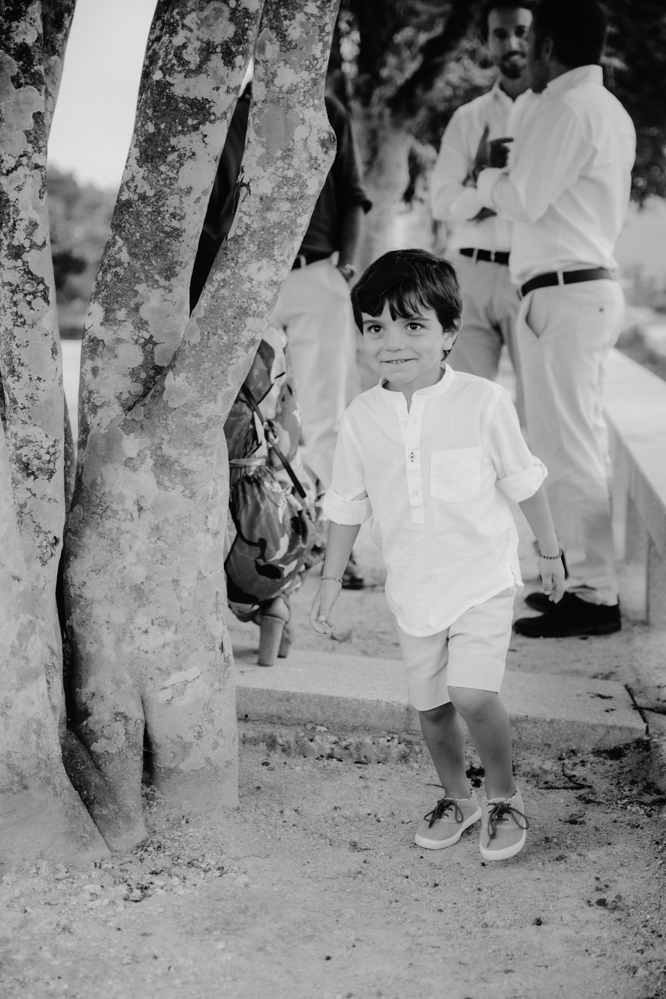 A vintage black and white photo of a child playing near trees.