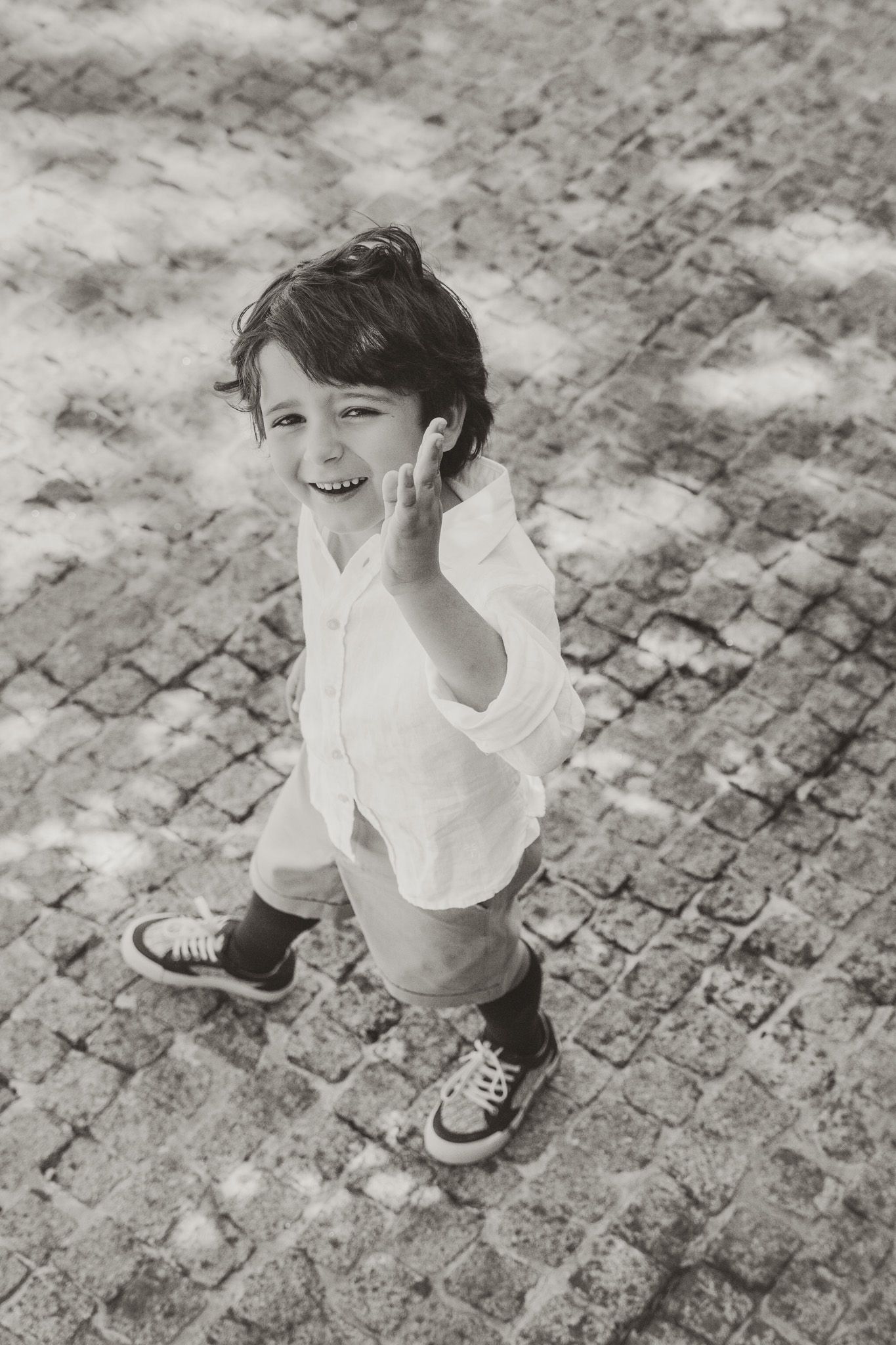 Black and white series of joyful movement captured on cobblestone ground.