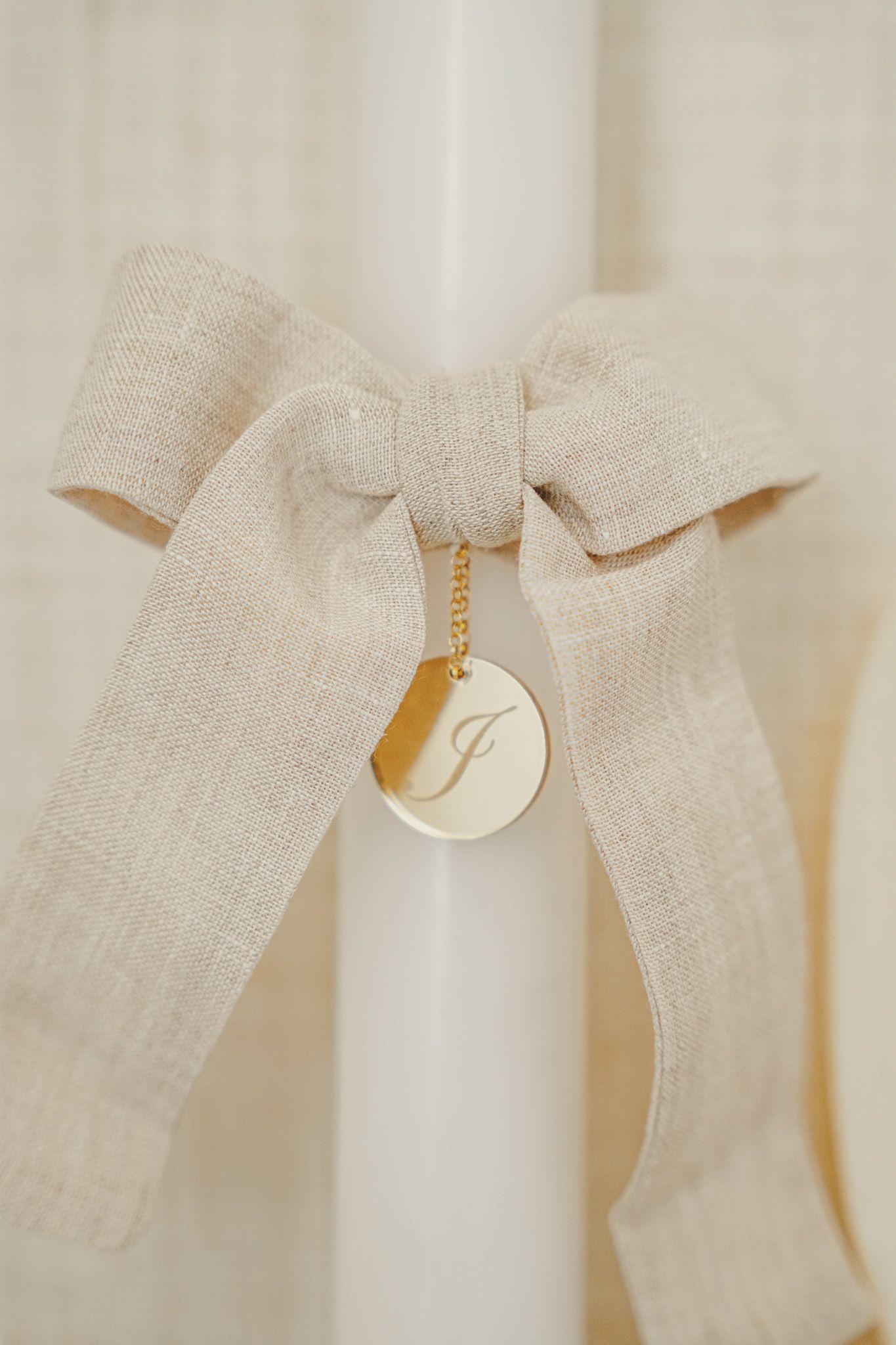 Delicate white linen bows arranged in a sequence against a neutral background.