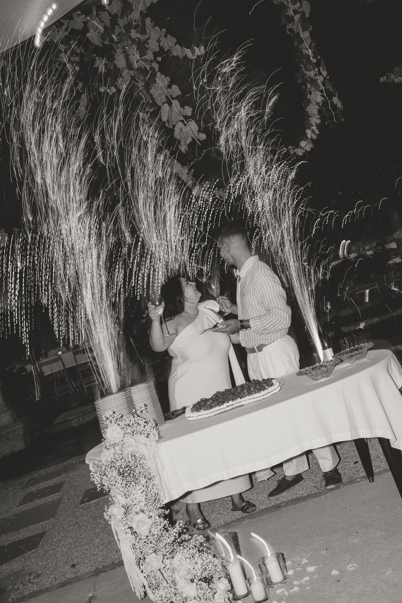 Black and white photo of a romantic moment at an outdoor reception.