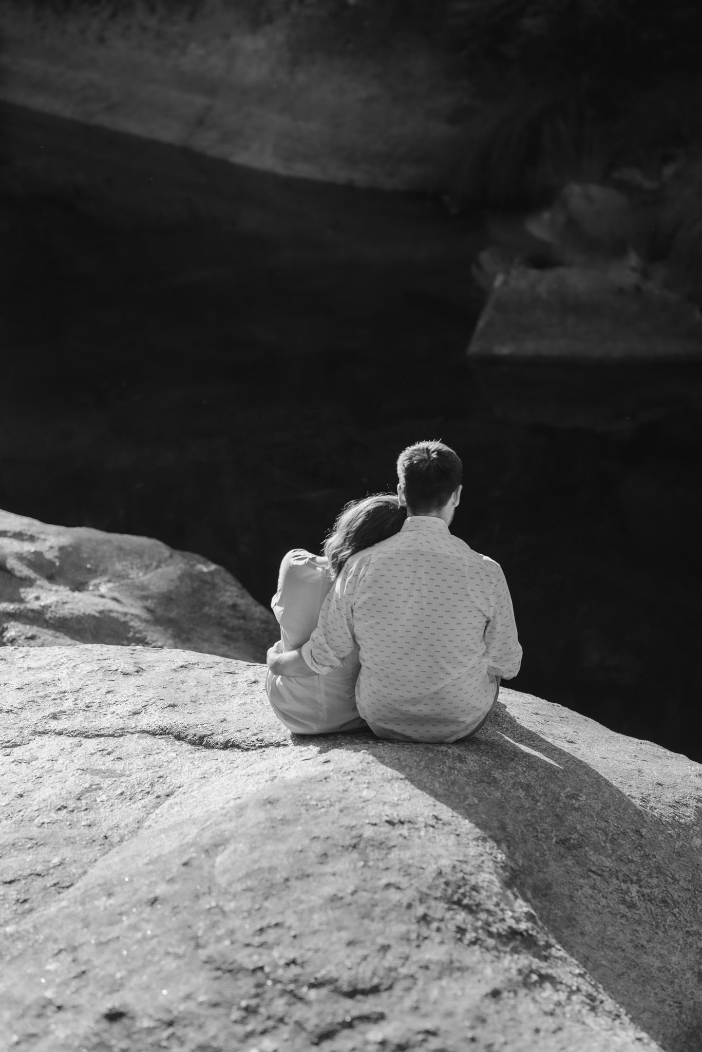 Black and white photograph of figures resting on a rocky ledge.