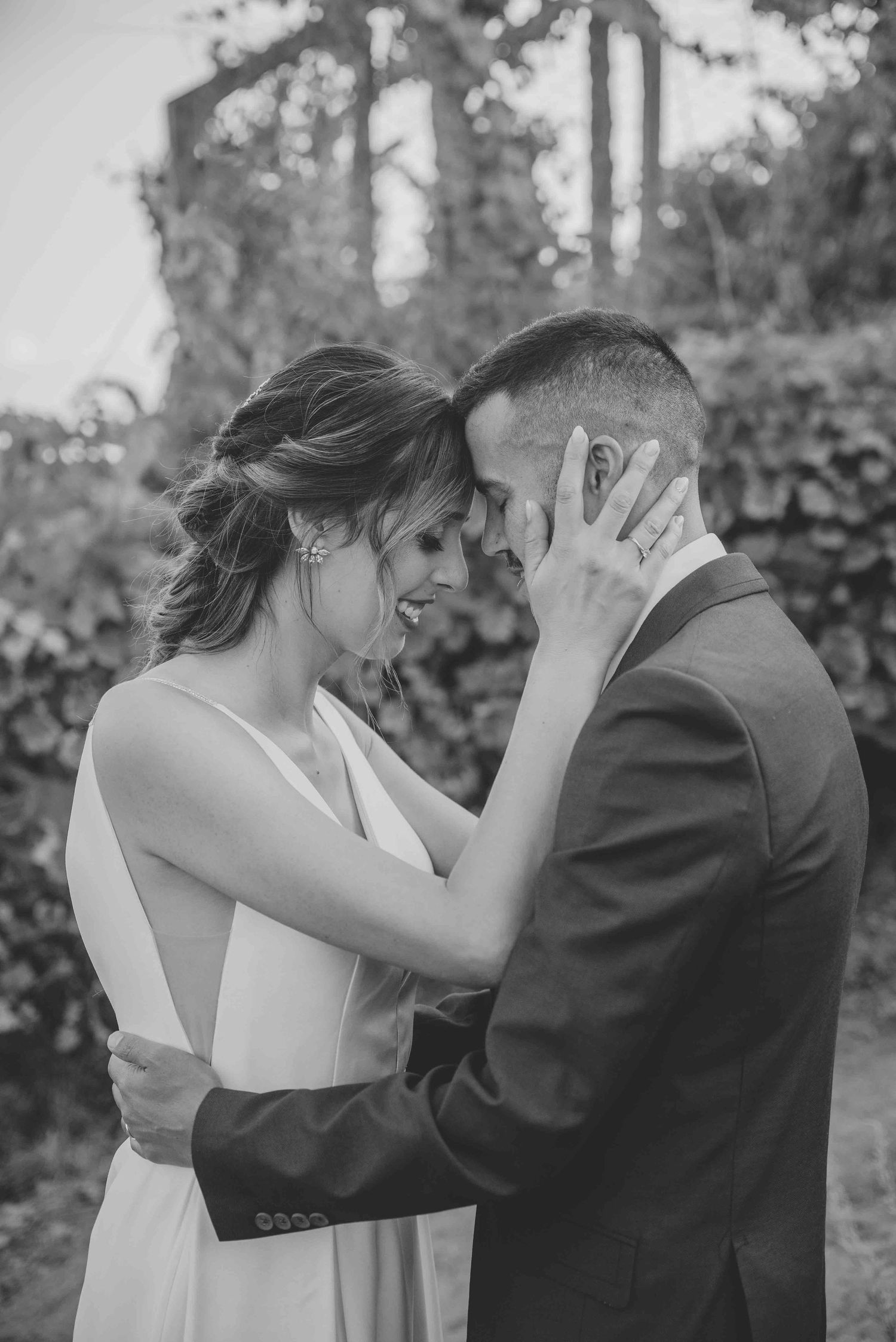 A romantic black and white photo sequence shows a couple sharing an intimate kiss in an outdoor garden setting.