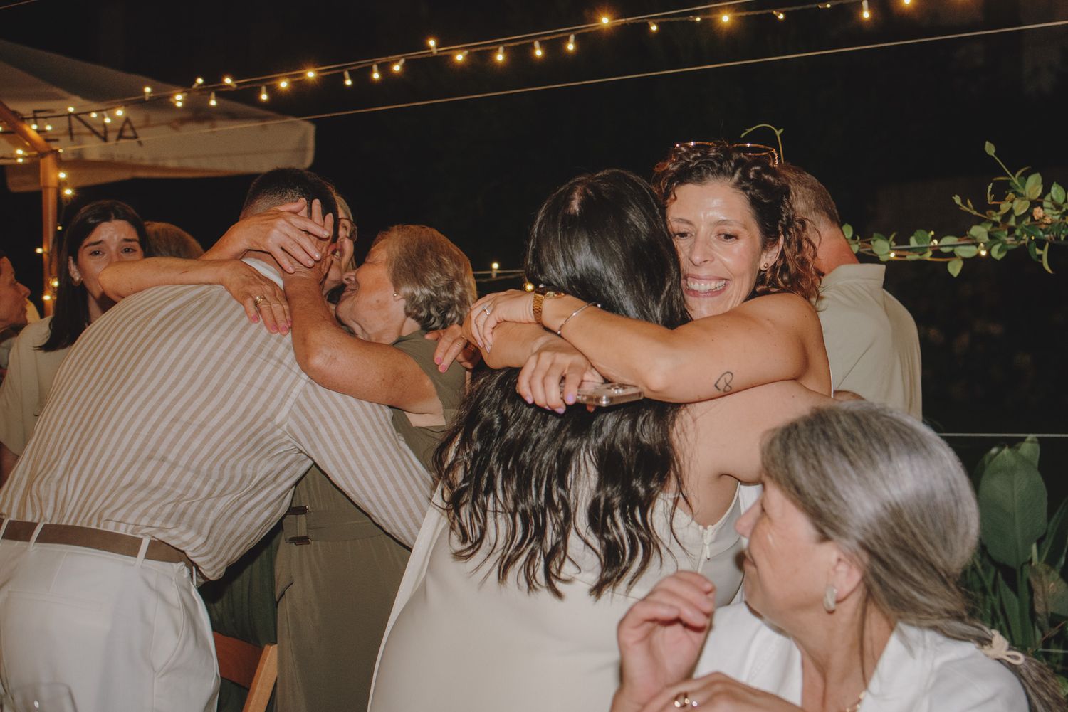 Candid moments captured during an outdoor evening wedding celebration.
