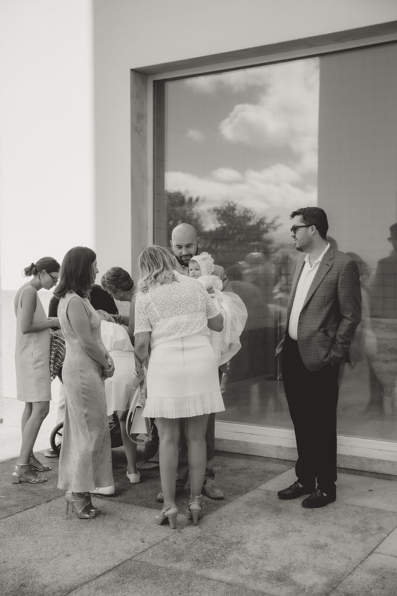 People gather outside a modern building to look at architectural plans and discuss the project details.