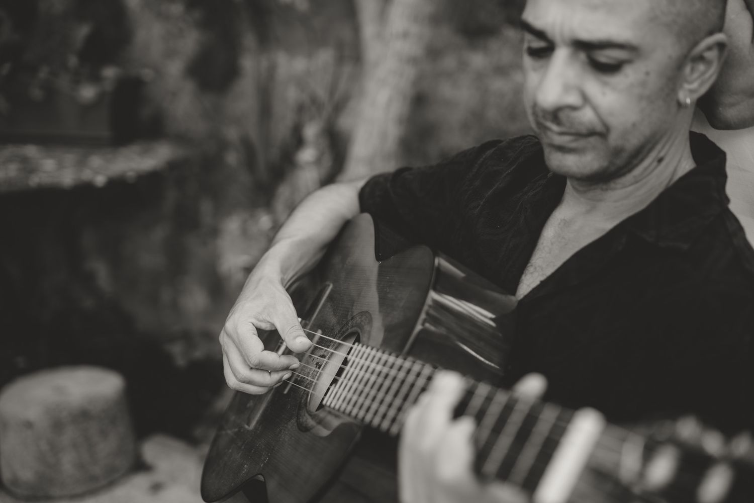 Series of black and white photos showing someone playing acoustic guitar.