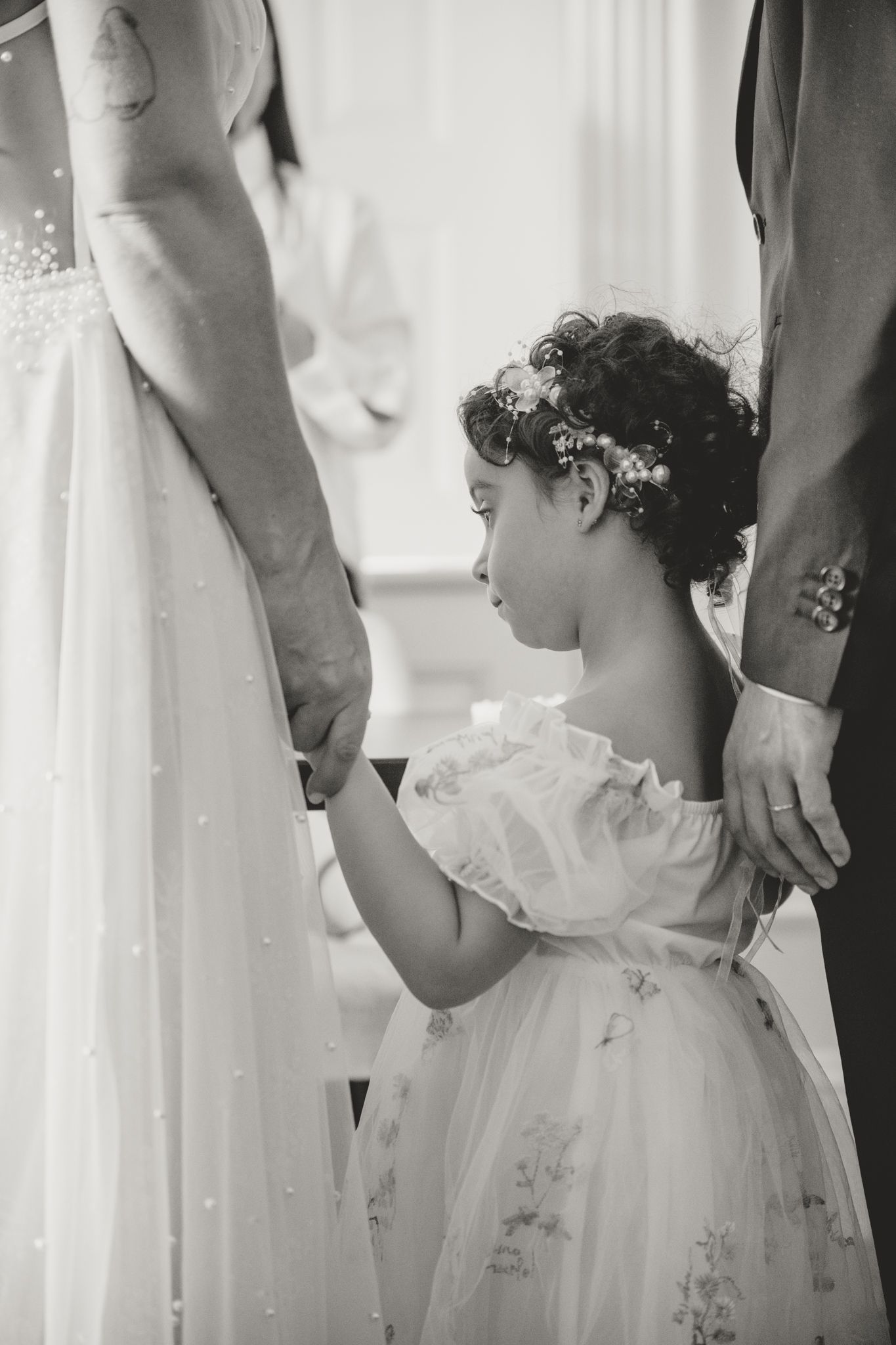 Detail shots of flower girl in white dress during wedding ceremony.