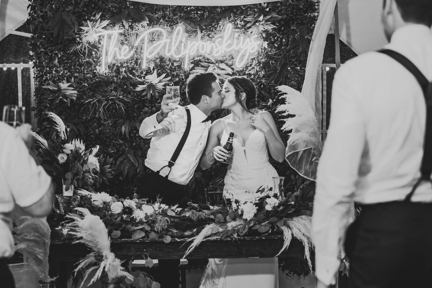 Black and white photo of a romantic wedding reception moment under string lights.